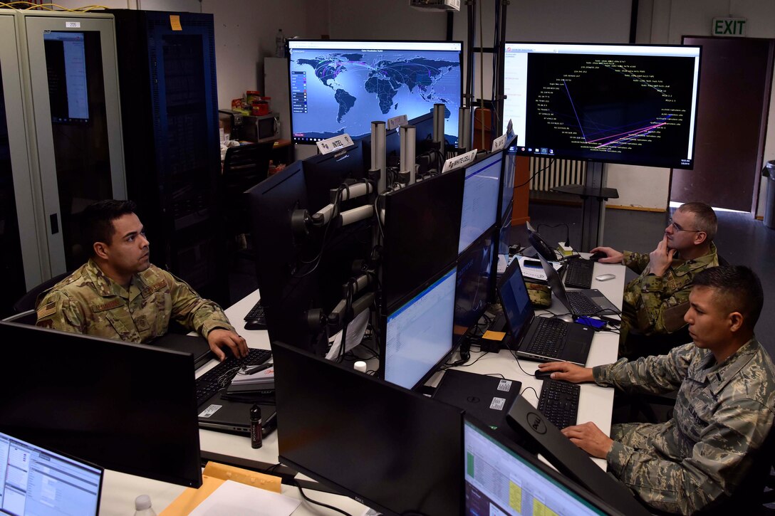 Service members work at a computer.