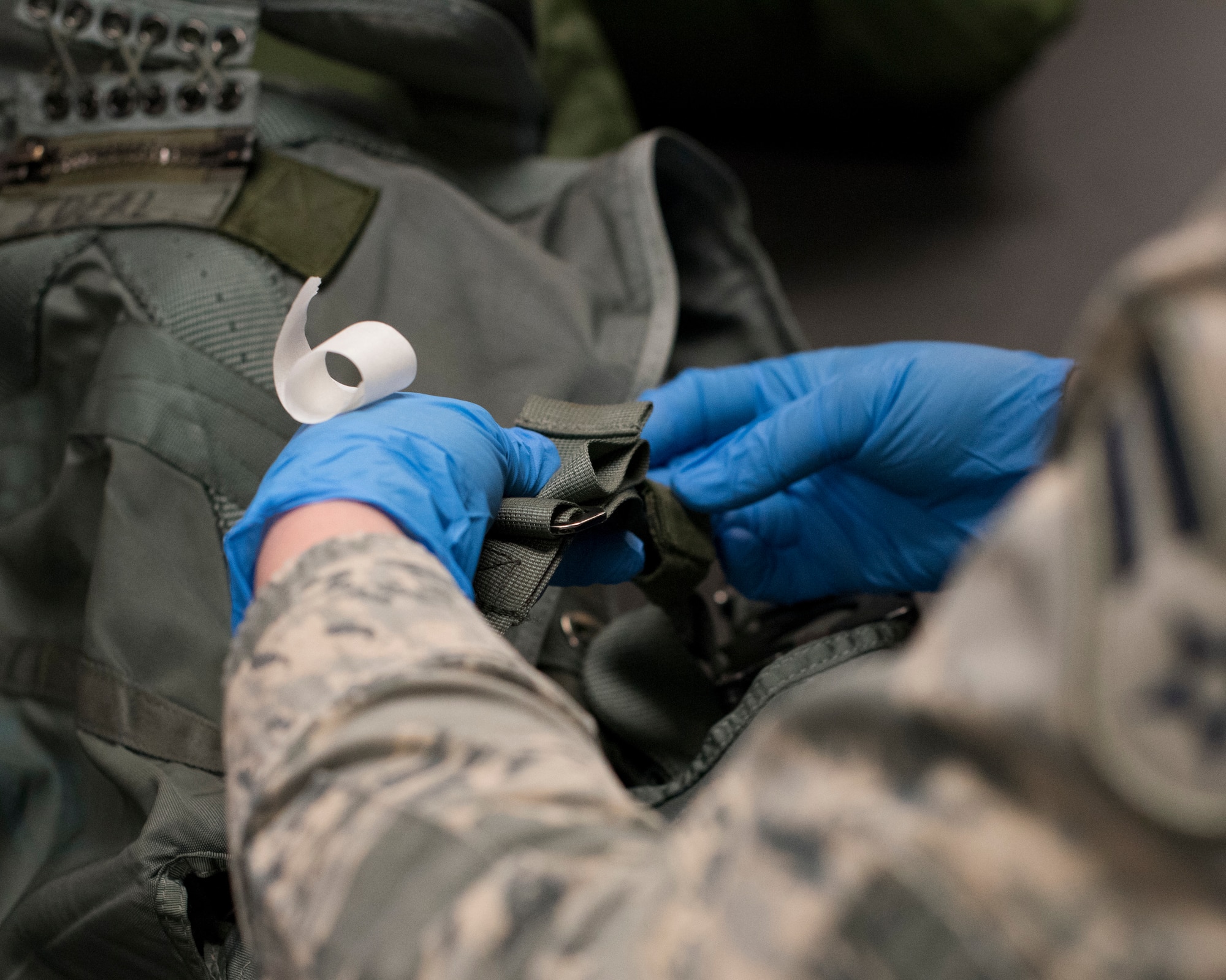 Airman 1st Class Kaci Ashby, 54th Operations Support Squadron Aircrew Flight Equipment technician, tapes a strap on a Life Preserver Unit, April 24, 2019, on Hill Air Force Base, Utah. Pilots with the 311th Fighter Squadron had the opportunity to fly over water during exercise Venom 19-01, and required specialized equipment in the event of an ejection over water. (U.S. Air Force photo by Staff Sgt. BreeAnn Sachs)
