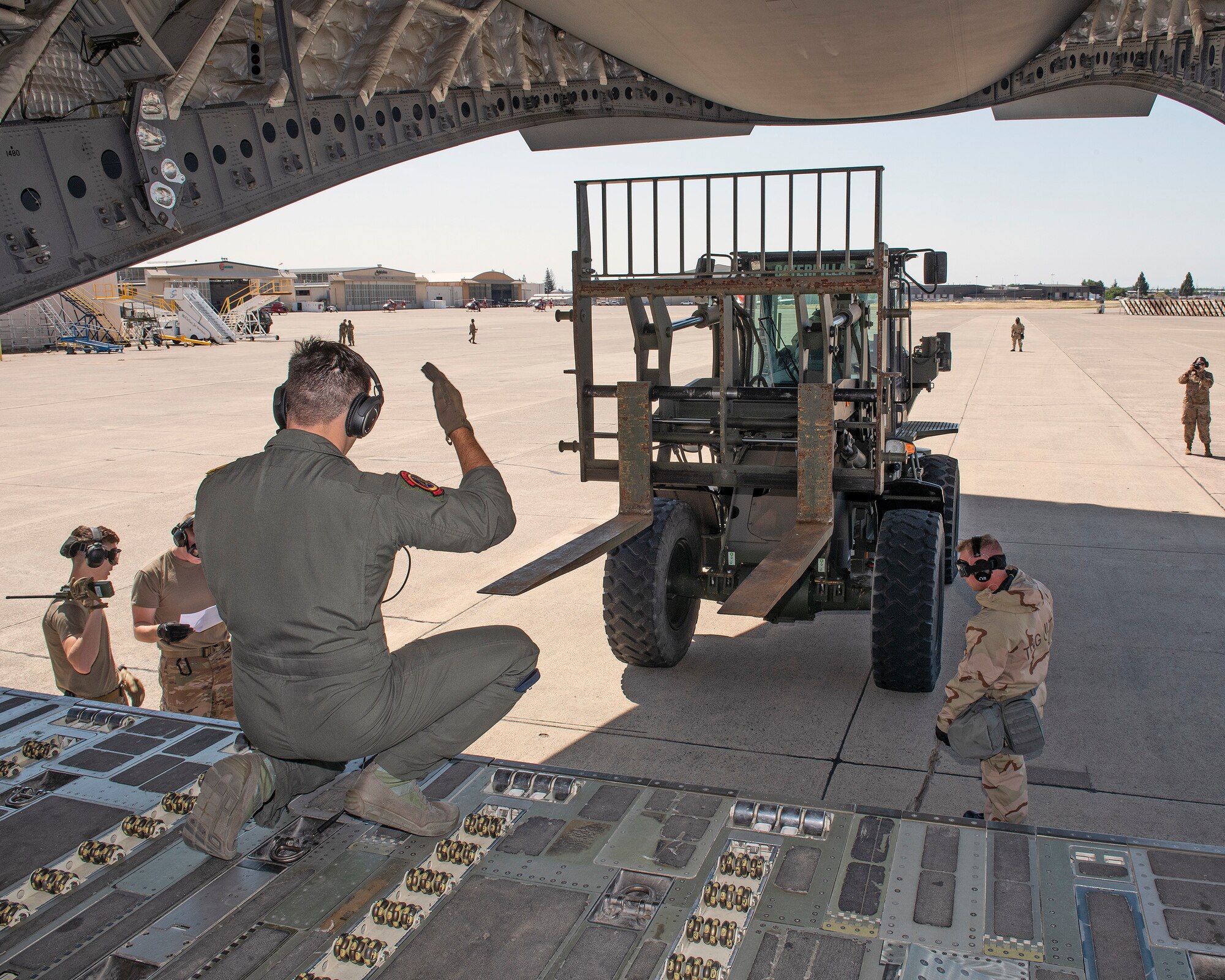 U.S. Air Force Airmen assigned to the 60th Aerial Port Squadron and the 21st Airlift Squadron perform a cargo load during a readiness exercise at Sacramento McClellan Airport, California, May 7, 2019. The base conducted a week-long exercise that evaluated Travis’ readiness and ability to execute and sustain rapid global mobility around the world. (U.S. Air Force photo by Louis Briscese)