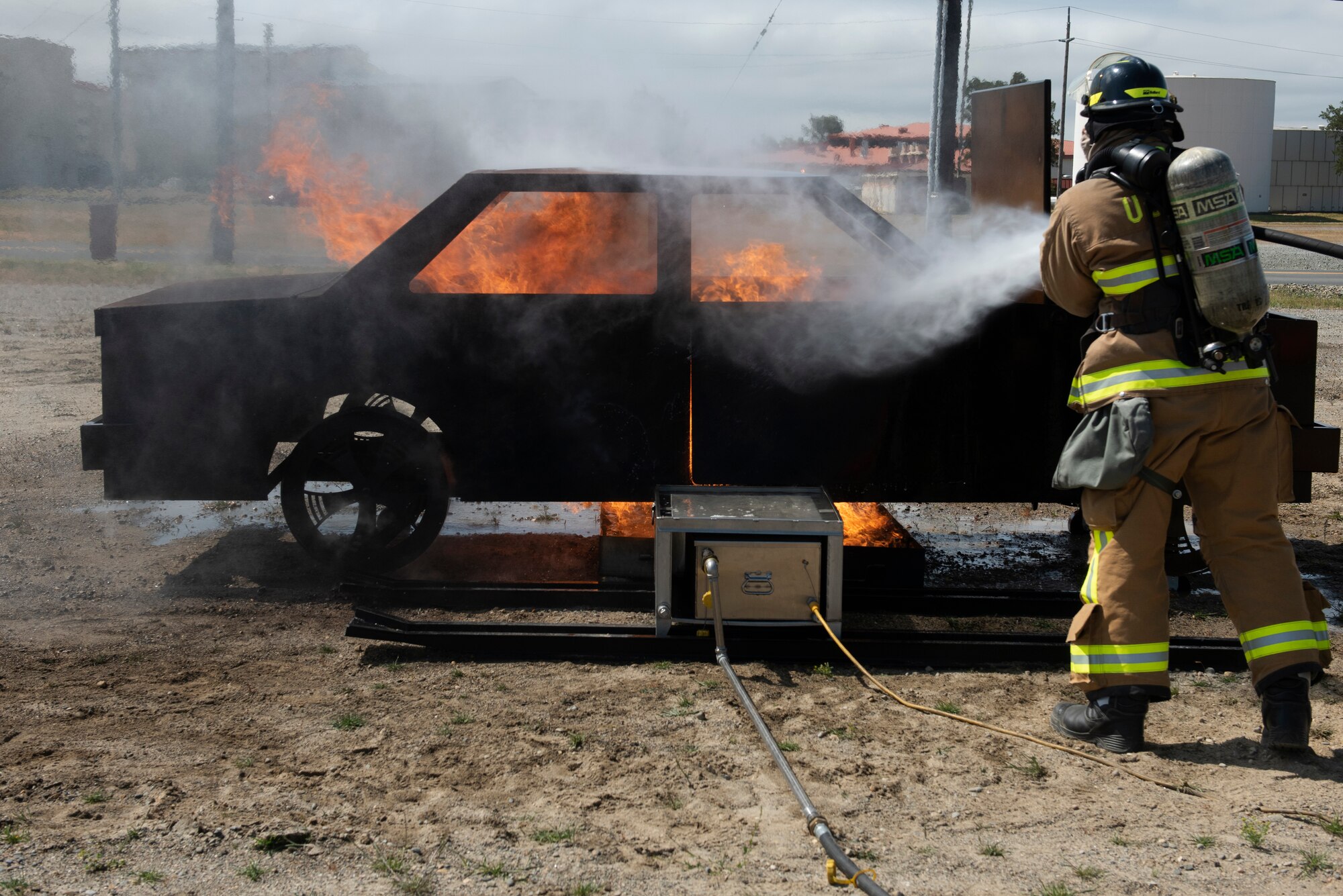 A Firefighter assigned to the 60th Civil Engineer Squadron works to extinguish a fire May 9, 2019 during a training exercise at Travis Air Force Base, California. The base conducted a weeklong exercise to evaluate its ability to execute and sustain rapid global mobility operations. (U.S. Air Force photo by Tech. Sgt. James Hodgman)