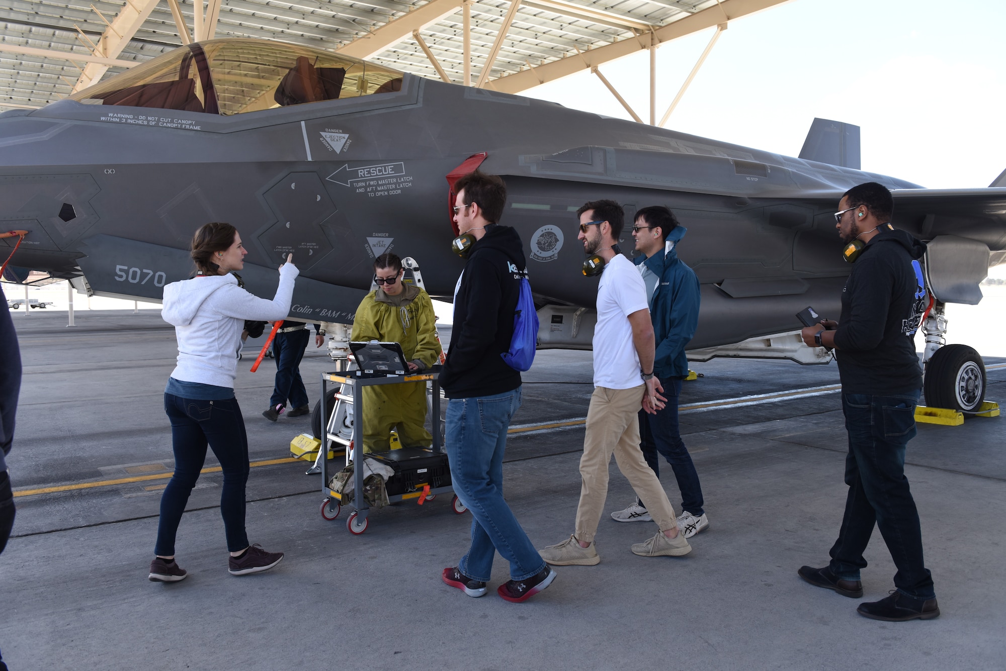 Maj. Jennifer Kannegaard, left, a product manager for the Mad Hatter F-35 Lightning II Joint Strike Fighter software project, leads her software design team to a working area for 57th Wing Bolt Aircraft maintenance unit maintainers April 10, 2019 at Nellis Air Force Base, Nev. Kannegaard’s team is working to equip Nellis maintainers with programs that will quickly and easily locate the most up-to-date technical orders for use in aircraft maintenance. (U.S. Air Force photo by Airman 1st Class Bailee Darbaise)