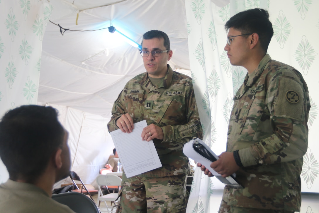 U.S. Army Reserve medical Soldiers, Capt. Angel Rivera and Spc. Christian Melendez attached to the 352nd Combat Support Hospital provide care to a Soldier.