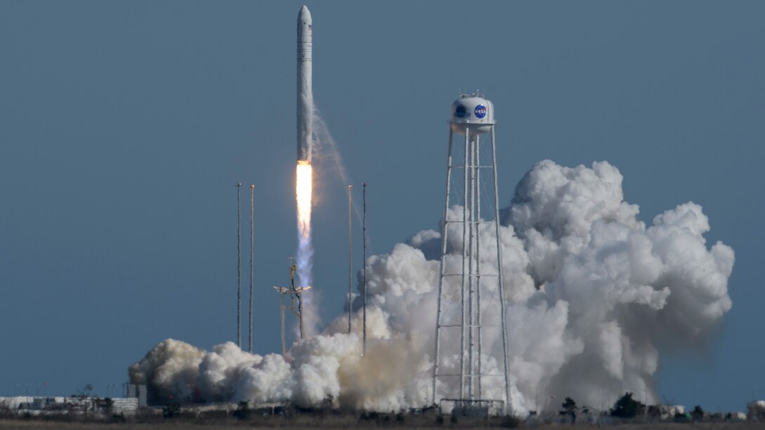The Northrop Grumman Antares rocket, with Cygnus resupply spacecraft onboard, launches with a plume of smoke below it