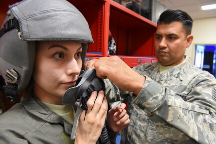 Airman 1st Class Ruby Rodriguez (left), assigned to the 149th Operations Group, gets fitted for a flight mask in preparation for her familiarization flight by Tech. Sgt. Rene Barrientes, a 149th OG aircrew flight equipment specialist, during Coronet Bronco May 2 at Mountain Home Air Force Base, Idaho. The annual training event deploys members of the Air National Guard’s 149th Fighter Wing, headquartered at Joint Base San Antonio-Lackland, to another environment in order to familiarize them with accomplishing mission objectives in an unfamiliar location.
