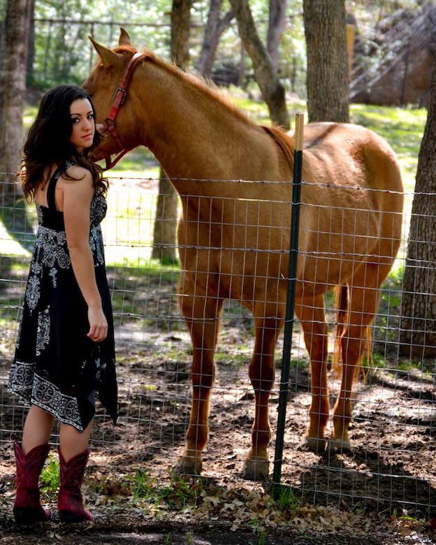 Woman poses with her horse.