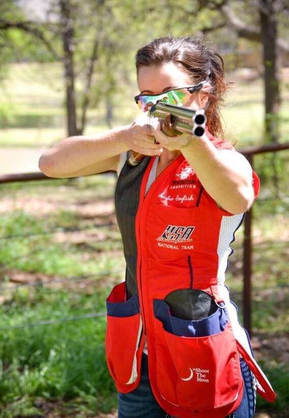A woman aims a shotgun.