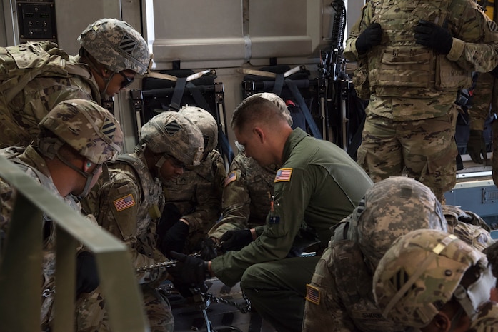 U. S. Air Force Senior Airman Branden Burkhart, loadmaster with the 300th Airlift Squadron Joint Base Charleston, S.C., teaches soldiers with the 414th Signal Company from Fort Stewart, Georgia how to secure equipment on a C-17 Globemaster III May 14, 2019, at Wright Army Airfield. The soldiers trained to be ready during an Expeditionary Deployment Readiness Exercise.(U.S. Air Force photo by Senior Airman William Brugge)