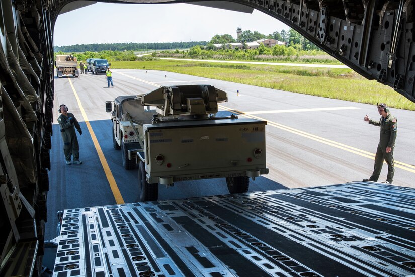 U. S. Air Force Tech. Sgt. Albert Pempsell and Senior Airman Branden Burkhart, loadmasters with the 300th Airlift Squadron Joint Base Charleston, S.C., help load equipment on to a C-17 Globemaster III May 14, 2019, at Wright Army Airfield. The equipment was loaded on to the aircraft for an Expeditionary Deployment Readiness Exercise to help bolster combat readiness. (U.S. Air Force photo by Senior Airman William Brugge)