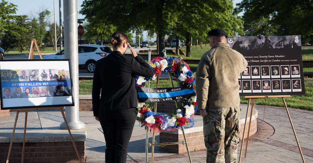 A defender with the 509th Security Forces Squadron, right, and an Air Force Office of Special Investigation agent salute the wreath they placed during the National Police Week opening ceremony May 13, 2019, at Whiteman Air Force Base, Missouri. During Police Week, members of both Air Force law enforcement agencies commemorate their fallen wingmen. (U.S. Air Force Photo by Airman Parker J. McCauley)