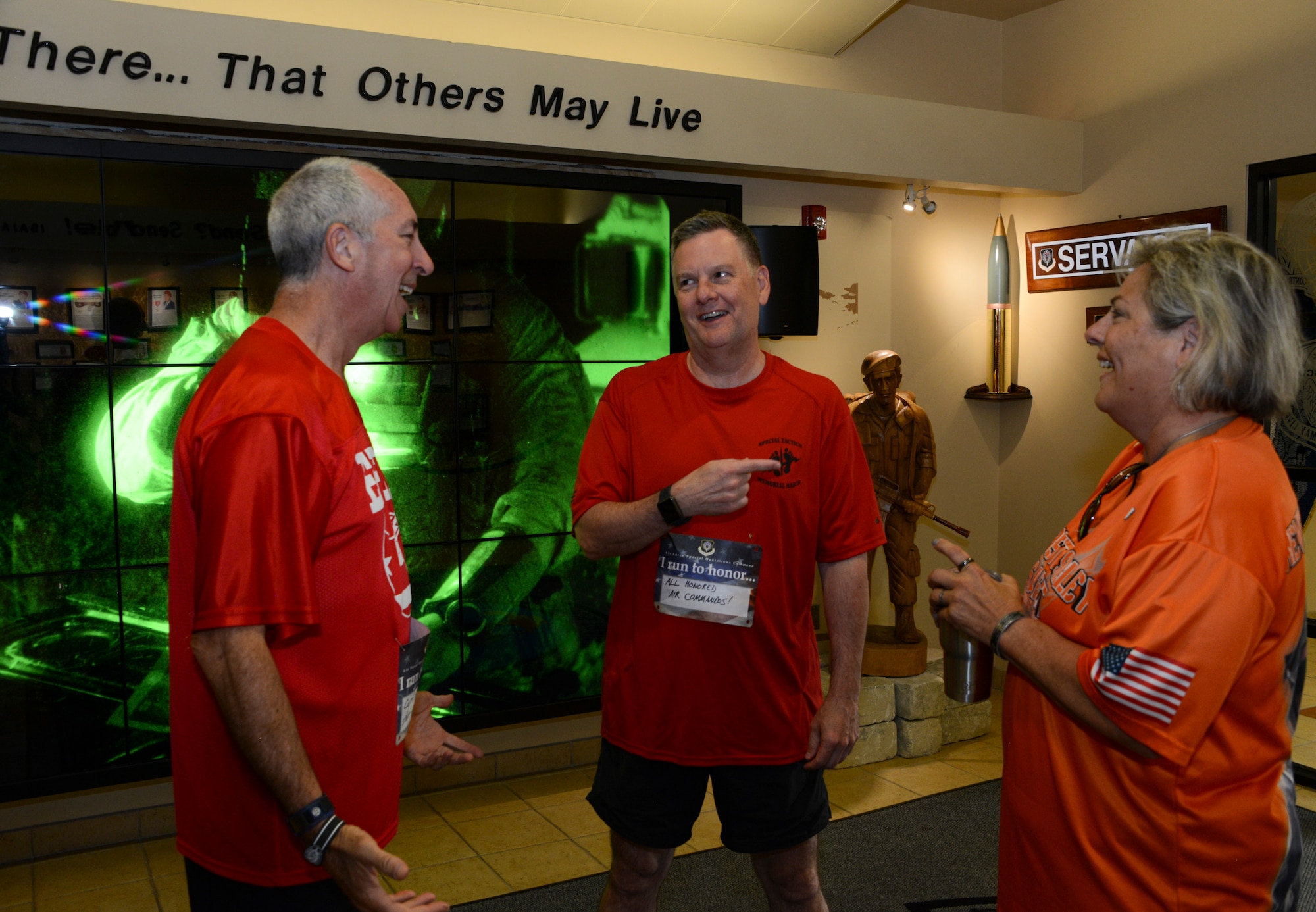 Three people talking in a lobby.