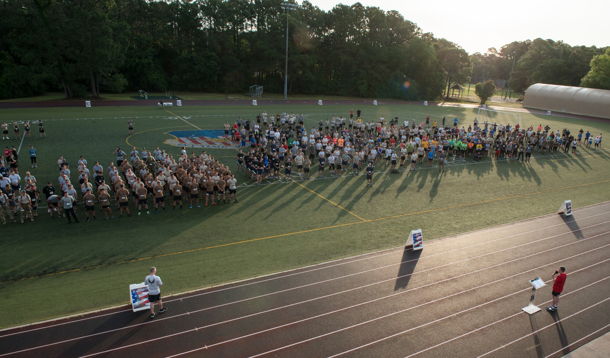 A group of people talking at a running track.