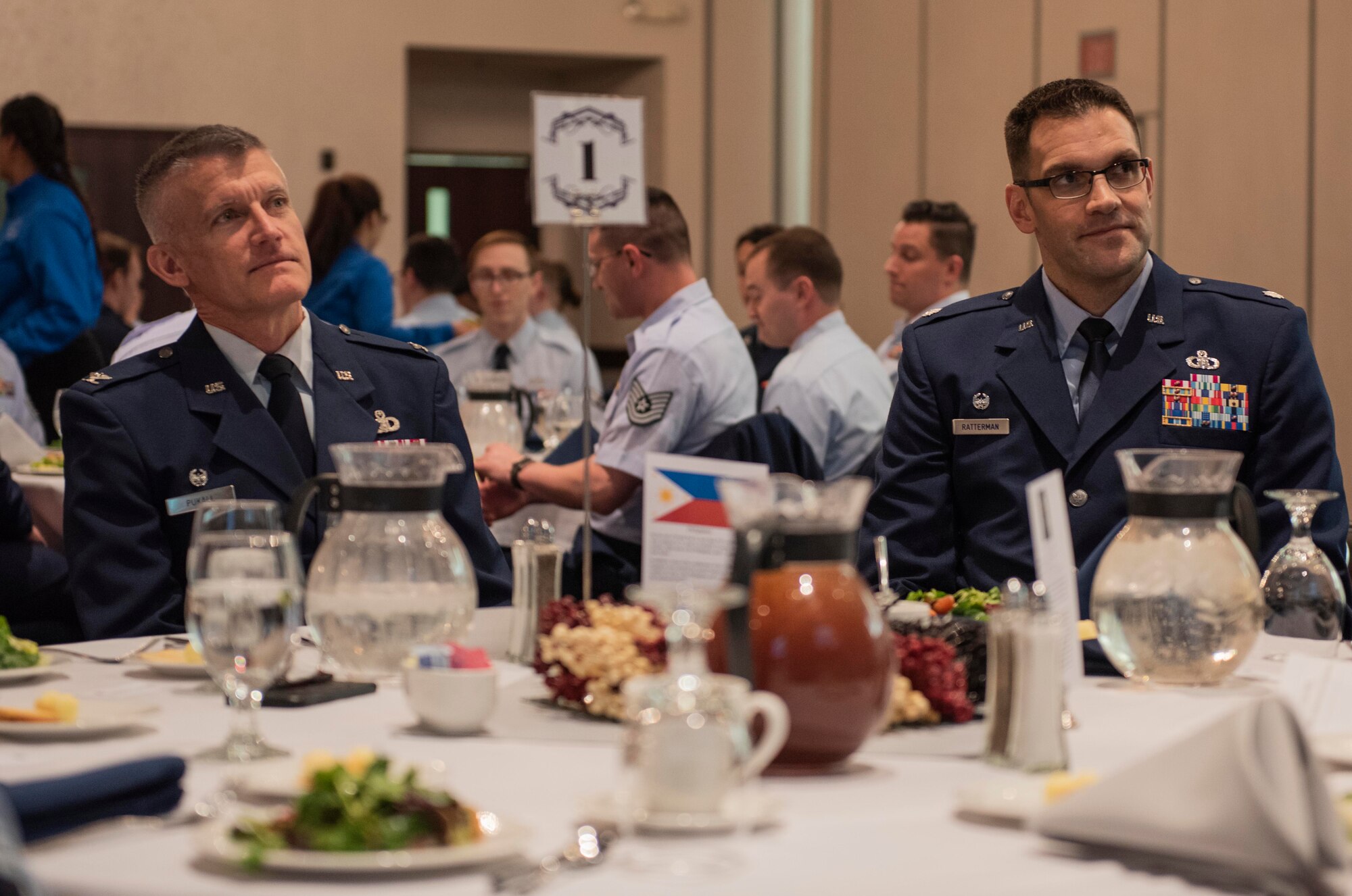 U.S. Air Force Col. Brian Pukall, 577th Weather Wing commander, and Lt. Col. Lance Ratterman, 15th Operational Weather Squad commander, listen to a guest speaker during the 15th OWS 20th anniversary dinner, Feb. 12, 2019, at Scott Air Force Base, Ill. During its 77 years, the 15th OWS has been located in six states and four countries across three different continents. It has spent the last 20 years assigned to Scott. (U.S. Air Force photo by Senior Airman Daniel Garcia)
