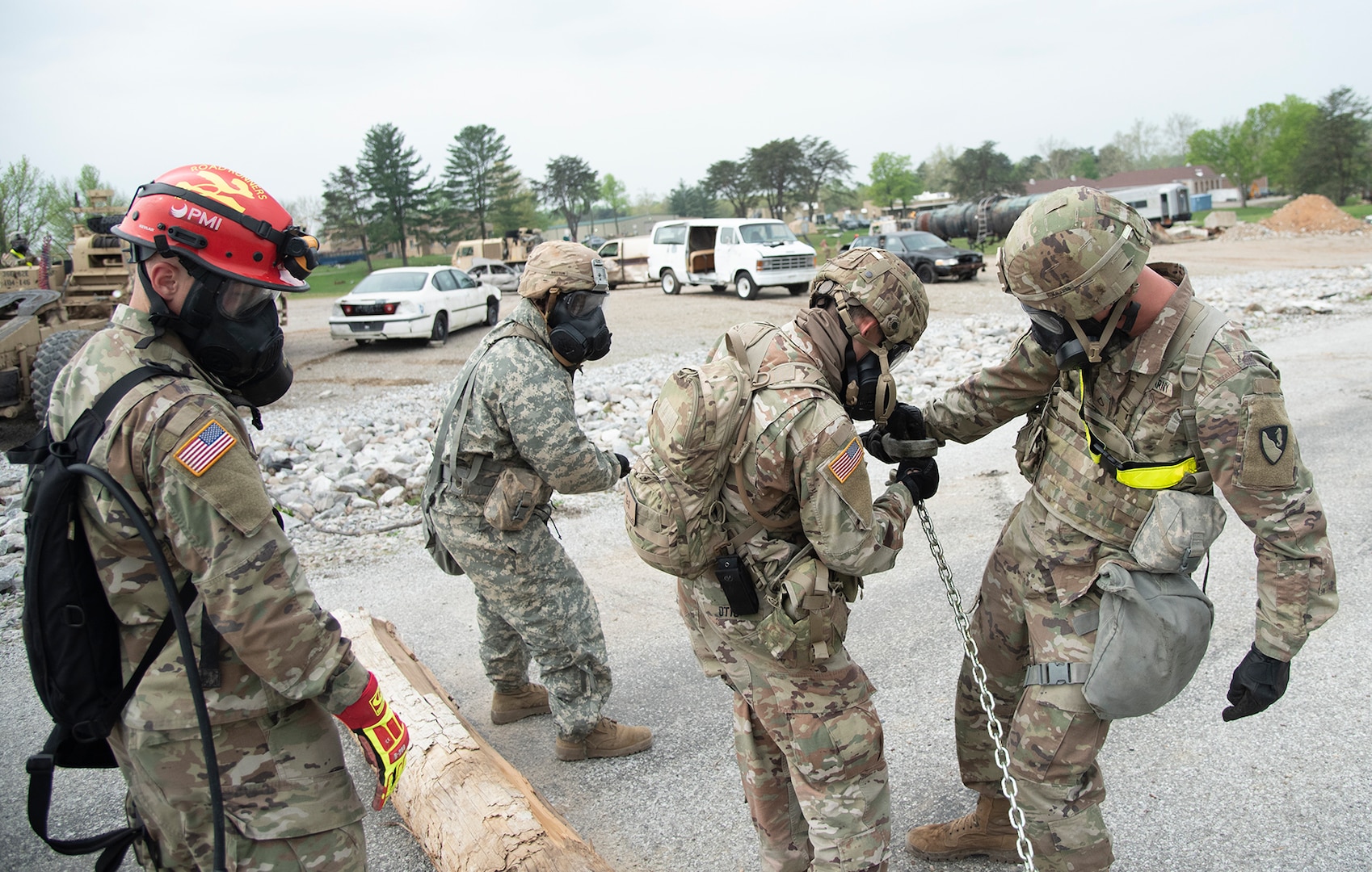 U.S. Soldiers with the 62nd Engineers, 104th Engineer Construction Company, from Ft. Hood, Texas, use Heavy Expanded Mobility Tactical Trucks (HEMTT) to pull debris (including vehicles and downed utility poles) from a road at Muscatatuck Urban Training Center in Butlerville, Ind., during Guardian Response 19, a homeland emergency response exercise which tests the ability of the military to respond to a man-made or natural disaster on April 30, 2019. The Soldiers are responding to a city following a mock nuclear detonation, so they must don gas masks and protective equipment while working. (U.S. Army photo by Master Sgt. Brad Staggs/released)