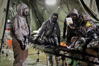 Soldiers from 546th Area Support Medical Company and 181st Chemical Company (Hazard Response), Task Force Ops, Joint Task Force Civil Support (JTFCS) bring a simulated patient through the Mass Casualty Decontamination line during Exercise Guardian Response at Muscatatuck Urban Training Center, May 4, 2019. When directed, JTFCS provides command and control of the 5,200-person Defense Chemical Biological Radiological Nuclear (CBRN) Response Force (DCRF) during a catastrophic crisis in support of civil authorities and the lead federal agency. Vibrant Response/Guardian Response is an annual, combined Command Post Exercise and Field Training Exercise which validates the ability of the DCRF forces to conduct the CBRN Response mission. (U.S. Army photo by 2nd Lt. Corey Maisch/released)