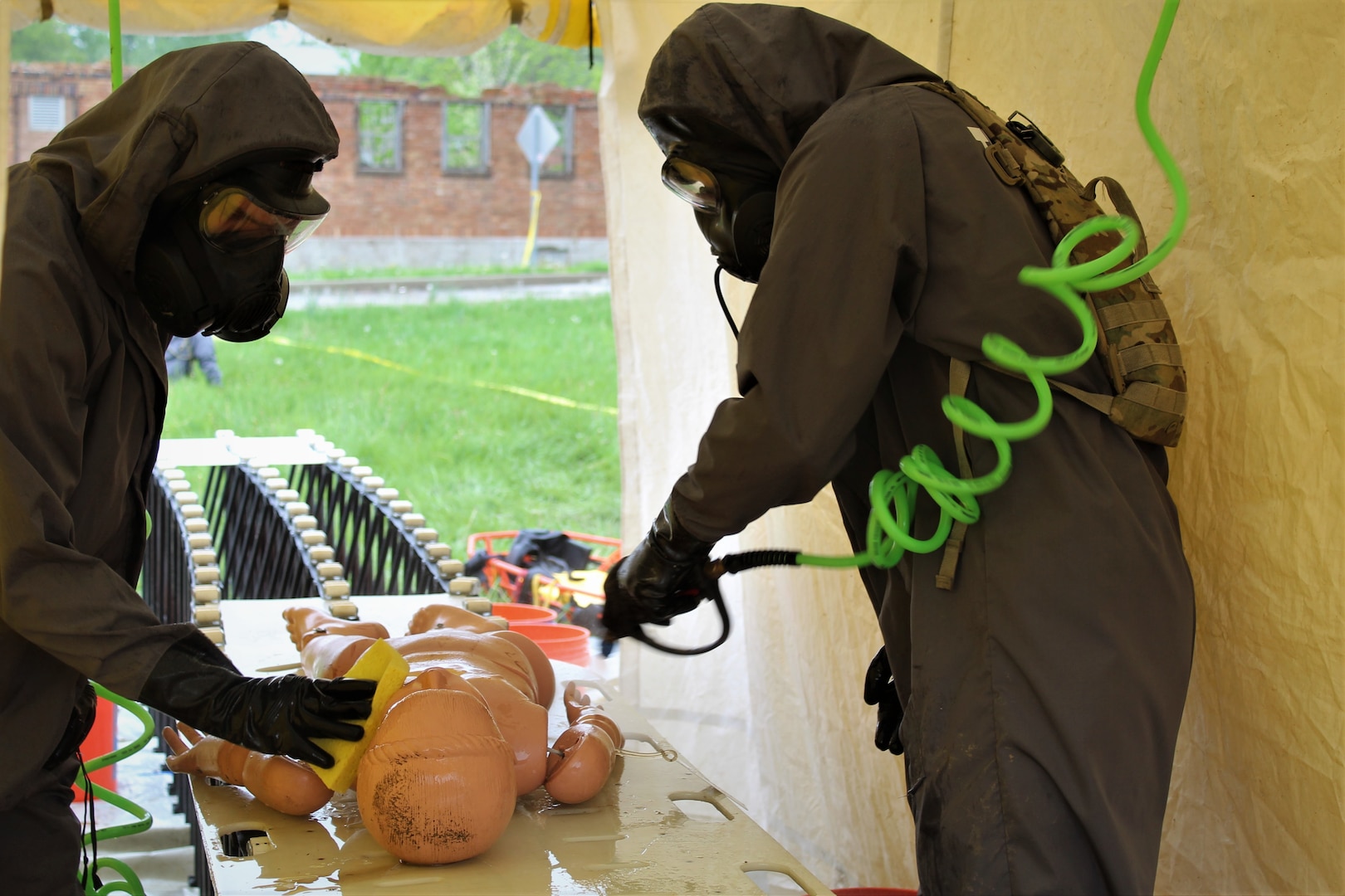 Soldiers from 68th Engineer Construction Company, Task Force Operations, Joint Task Force Civil Support (JTFCS), decontaminate a manikin after rescuing it from an irradiated rubble pile during Exercise Guardian Response at Muscatatuck Urban Training Center, May 4, 2019. When directed, JTFCS provides command and control of the 5,200-person Defense Chemical Biological Radiological Nuclear (CBRN) Response Force (DCRF) during a catastrophic crisis in support of civil authorities and the lead federal agency. Vibrant Response/Guardian Response is an annual, combined Command Post Exercise and Field Training Exercise which validates the ability of the DCRF forces to conduct the CBRN Response mission. (U.S. Army photo by 2nd Lt. Corey Maisch/released)