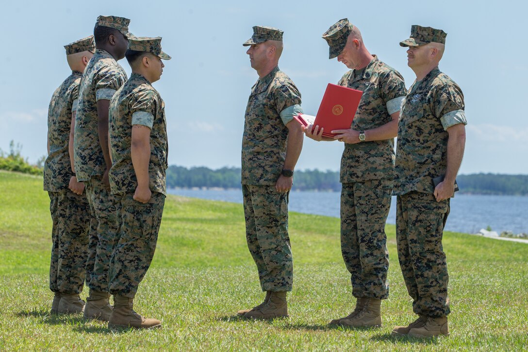 U.S. Marine Corps Brig. Gen. Kevin J. Stewart, left, commanding general of 2nd Marine Logistics Group, Sgt. Maj. Steven L. Lunsford, center, sergeant major of 2nd MLG, and Master Chief Petty Officer Richard A. Jackson, right, command master chief of 2nd MLG, present awards to Marines and Sailors at Camp Lejeune, North Carolina, May 14, 2019.  During the ceremony, annual awards were presented to Marines and Sailors who displayed exceptional work ethic and leadership qualities. (U.S. Marine Corps photo by Cpl. Tyler Stewart)