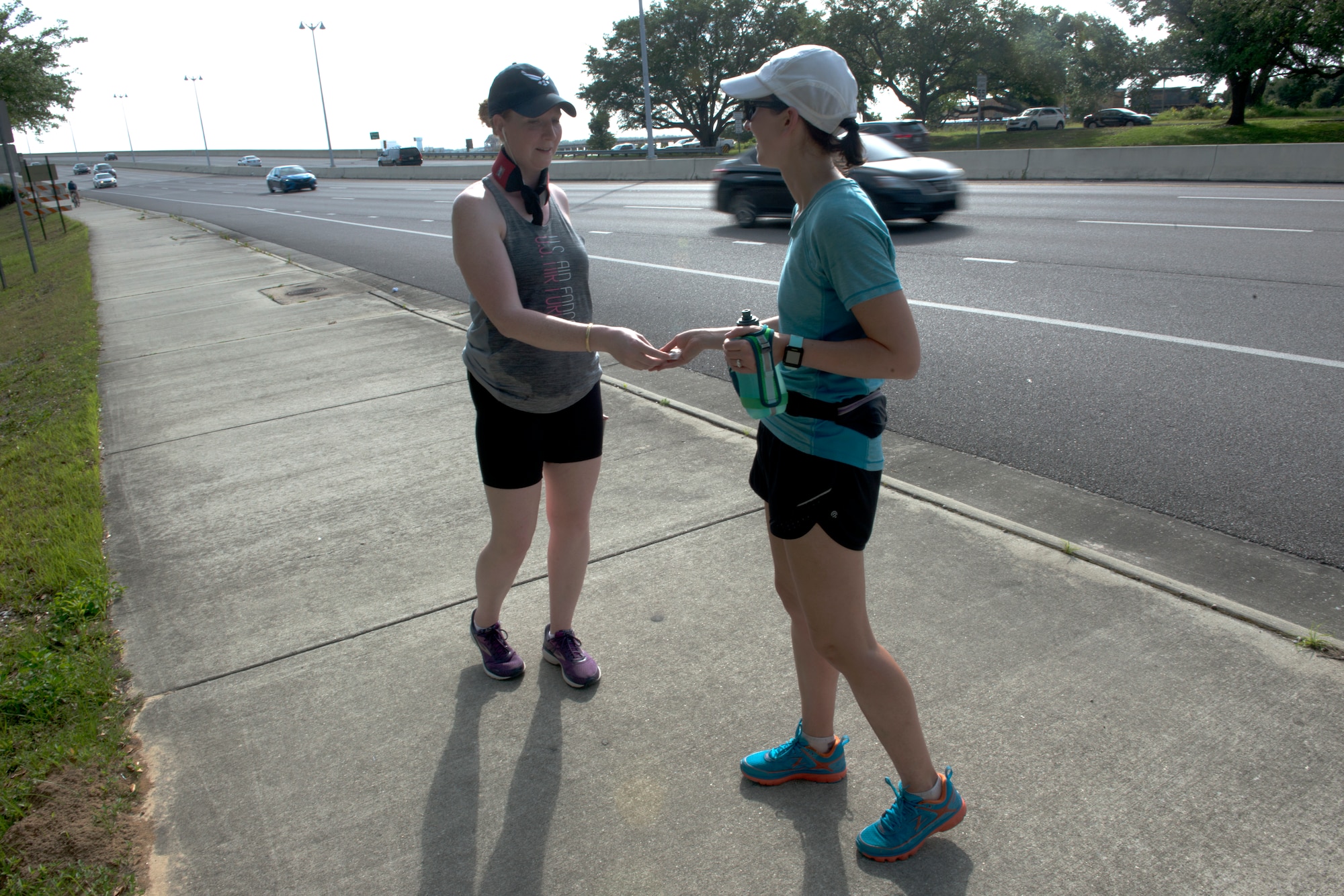 U.S. Air Force Capt. Kelly Hiser, 335th Training Squadron force support officer, hands a combat controller coin to another team member during the Crawfish Relay at Biloxi, Mississippi, May 3, 2019. The relay team, "Unicorn of the Sea," accepted the challenge of the Crawfish Relay to not only push themselves, but to honor two special tactics Airmen killed in action, U.S. Air Force Master Sgt. John Chapman and U.S. Air Force Staff Sgt. Dylan Elchin. The team carried two combat controller coins to symbolize them and handed them off at each checkpoint. (U.S. Air Force photo by Airman Seth Haddix)