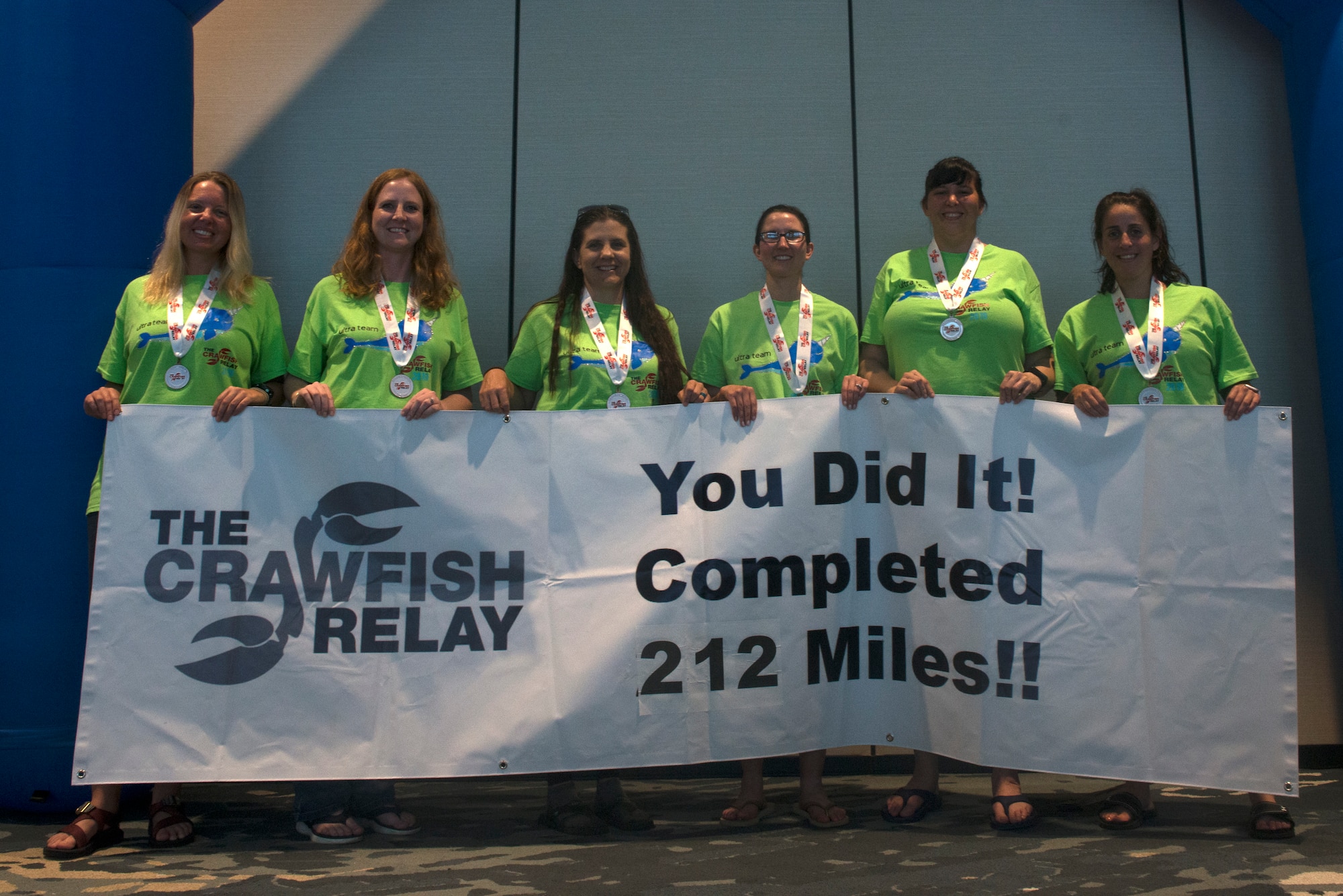 The Crawfish Relay team holds a finish line banner at Gulf Shores, Alabama, May 4, 2019. The relay team, "Unicorn of the Sea," accepted the challenge of the Crawfish Relay to not only push themselves, but to honor two special tactics Airmen killed in action, U.S. Air Force Master Sgt. John Chapman and U.S. Air Force Staff Sgt. Dylan Elchin. (U.S. Air Force photo by Airman Seth Haddix)