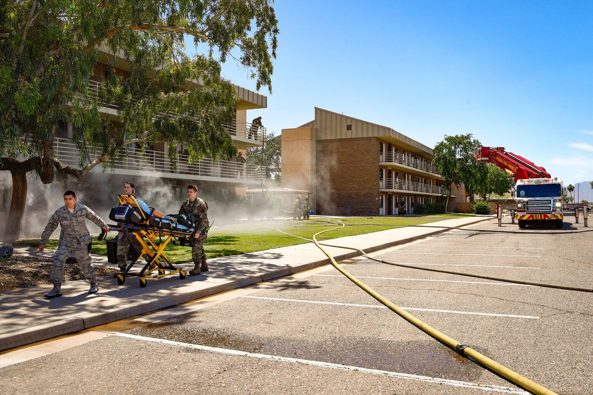 Paramedics transport a mannequin with simulated injures to an ambulance during a joint training exercise May 3, 2019, at Luke Air Force Base, Ariz. The exercise tested the ability of different fire departments to work together successfully when responding to emergency calls that might include multi-level structural fires or injuries. (U.S. Air Force photo by Airman 1st Class Zoie Cox)