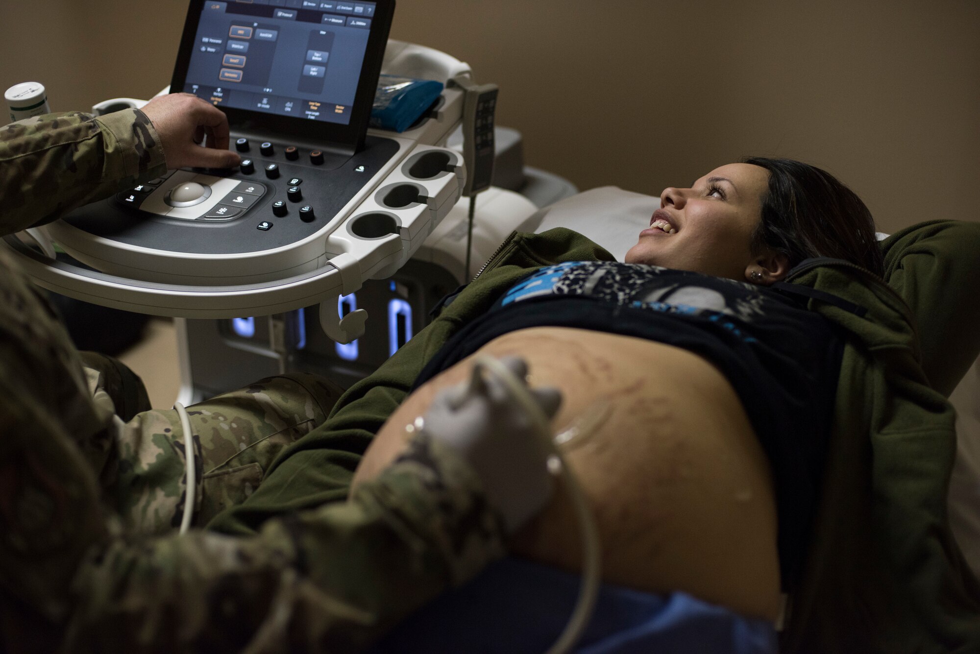 U.S. Air Force Staff Sgt. Nance Pea, the 35th Surgical Operations Squadron ultrasound NCO in charge, performs an ultrasound on Annalisa McCormick, spouse of Airman 1st Class Kristopher McCormick, a 35th Civil Engineer Squadron pavement and equipment journeyman, at Misawa Air Base, Japan, April 10, 2019. This procedure uses sound waves to show pictures of a baby in the womb, allowing health care providers to monitor a baby’s health and development. (U.S. Air Force photo by Senior Airman Collette Brooks)