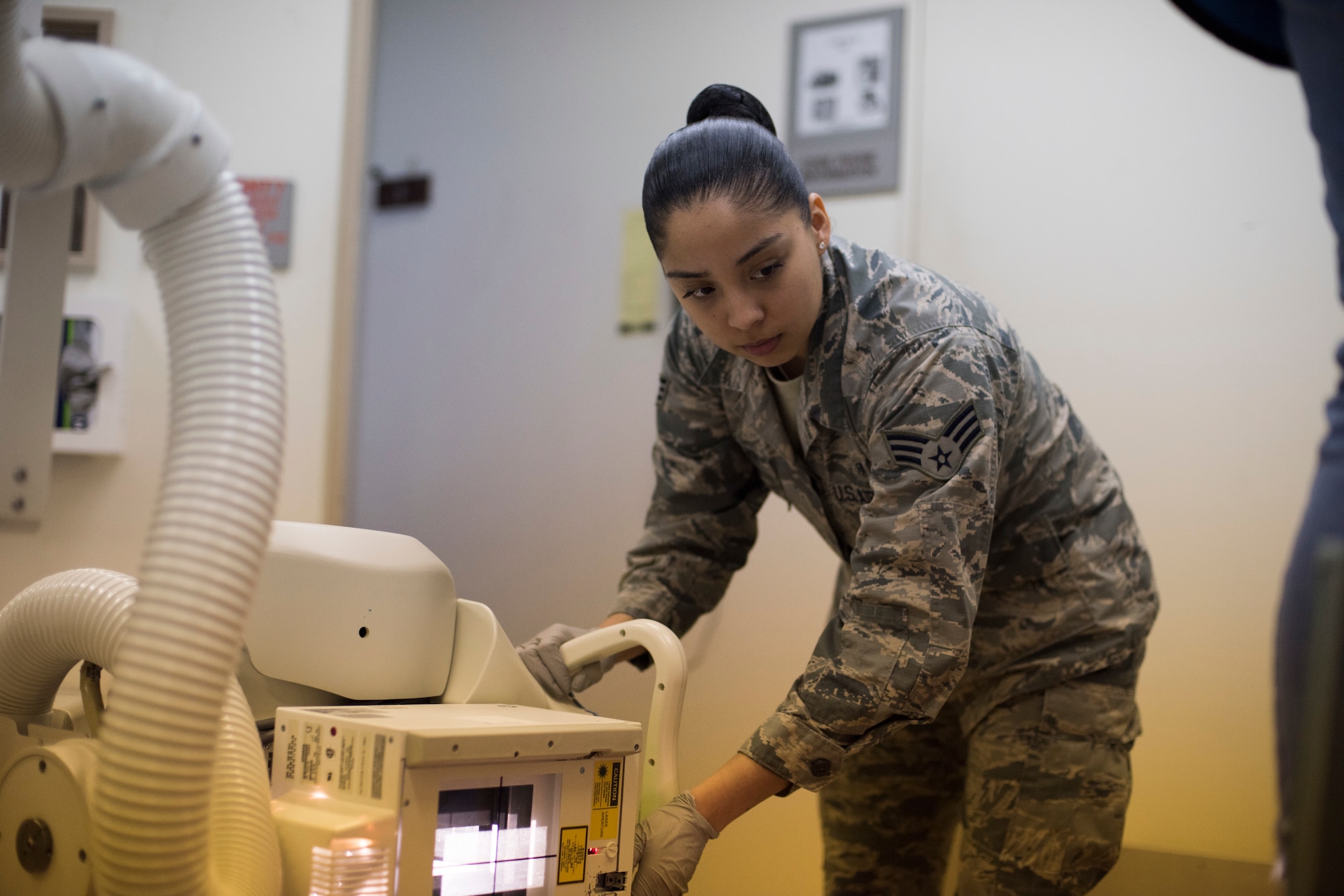 U.S. Air Force Senior Airman Darae Aguilar, a 35th Surgical Operations Squadron diagnostic imaging technician, positions an x-ray tube to take an image of a patient’s foot at Misawa Air Base, Japan, April 10, 2019. An x-ray tube is a vacuum tube that converts electrical input power into x-rays creating pictures and images of a human body’s insides. (U.S. Air Force photo by Senior Airman Collette Brooks)