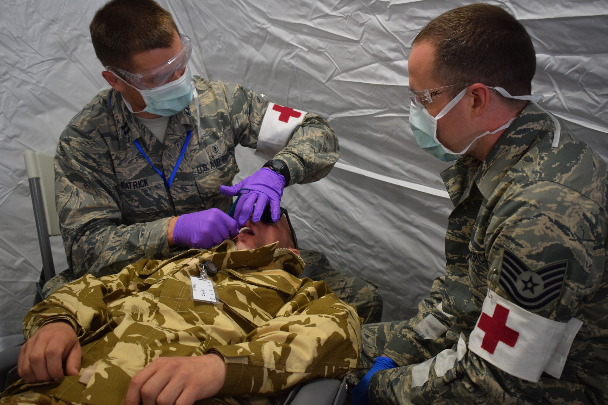 Capt. Thomas Patrick, dentist, 86th Medical Group, Ramstein Air Base, Germany, and Tech Sgt. Joshua Diel, dental assistant, 86 MDG, Ramstein AB, Germany, participate in a multinational medical exercise drill during Vigorous Warrior 19, Cincu Military Base, Romania, April 8, 2019. Vigorous Warrior 19 is NATO’s largest-ever military medical exercise, uniting more than 2,500 participants from 39 countries to exercise experimental doctrinal concepts and test their medical assets together in a dynamic, multinational environment (U.S. Air Force photo by 1st Lt. Andrew Layton).