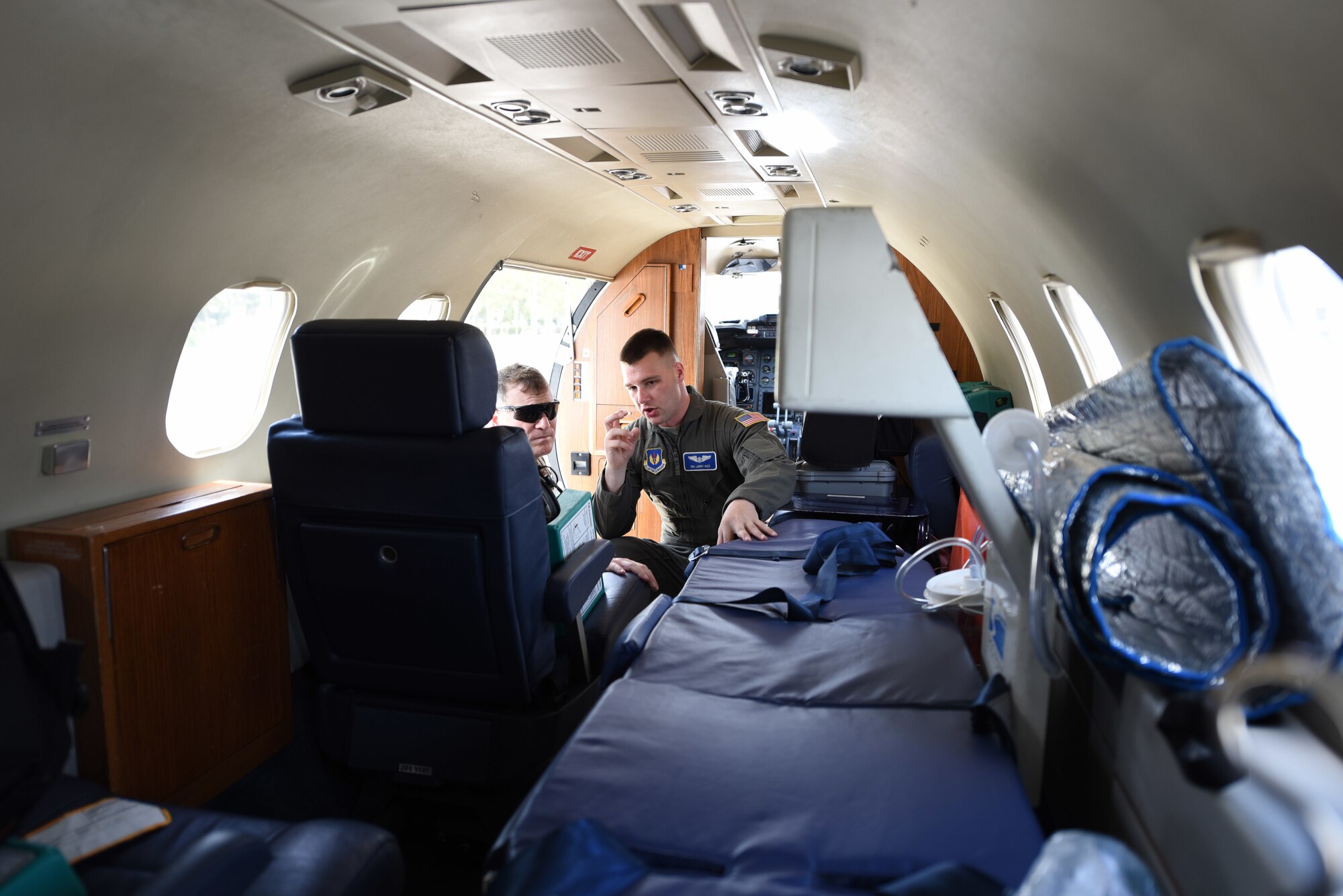 U.S. Air Force Senior Airman Larry Nice, 86th Aeromedical Evacuation Squadron technician, explains 86th AES medical procedures to a Hellenic combat medic, aboard a C-21 Learjet, during exercise Stolen Cerberus VI, May 10, 2019, on Elefsis Air Base, Greece. Stolen Cerberus is an annual bilateral training event with the Hellenic air force designed to enhance interoperability and airlift capabilities through realistic joint air operations training, including aeromedical evacuation operations and airlift and airdrop capabilities.