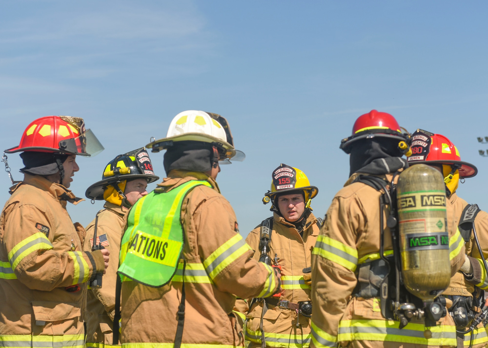 Firefighters discuss the appropriate response to a simulated fuel spill at RAF Mildenhall, England, May 15, 2019. The exercise tested the base's response to 65,000 gallons of spilled fuel. The fuel spill exercise was conducted to test the base’s response and recovery capabilities. (U.S. Air Force photo by Airman 1st Class Joseph Barron)