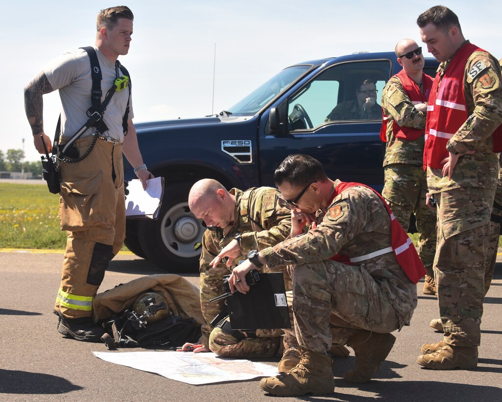 Wing inspection team members and exercise participants from the 100th Air Refueling Wing look over a base map during a fuel spill exercise at RAF Mildenhall, England, May 15, 2019. Exercise participants were evaluated based on their performance during the exercise.  (U.S. Air Force photo by Airman 1st Class Joseph Barron)