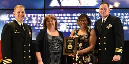 IMAGE: FREDERICKSBURG, Va. (May 10, 2019) – Feline Agwumezie holds the Distinguished Community Service Award moments after receiving it from Naval Surface Warfare Center Dahlgren Division (NSWCDD) leadership at the command’s annual honor awards ceremony. Agwumezie was recognized for her contribution to improving the community through service and outreach. Her work with children and the less fortunate serves as an example of volunteerism and the spirt that embodies Dahlgren Division’s commitment to the community. Standing left to right: NSWCDD Dam Neck Activity Commanding Officer Cmdr. Andrew Hoffman; NSWCDD Deputy Technical Director Angela Beach; Agwumezie; and NSWCDD Commanding Officer Cmdr. Stephen ‘Casey’ Plew.  (U.S. Navy photo/Released)