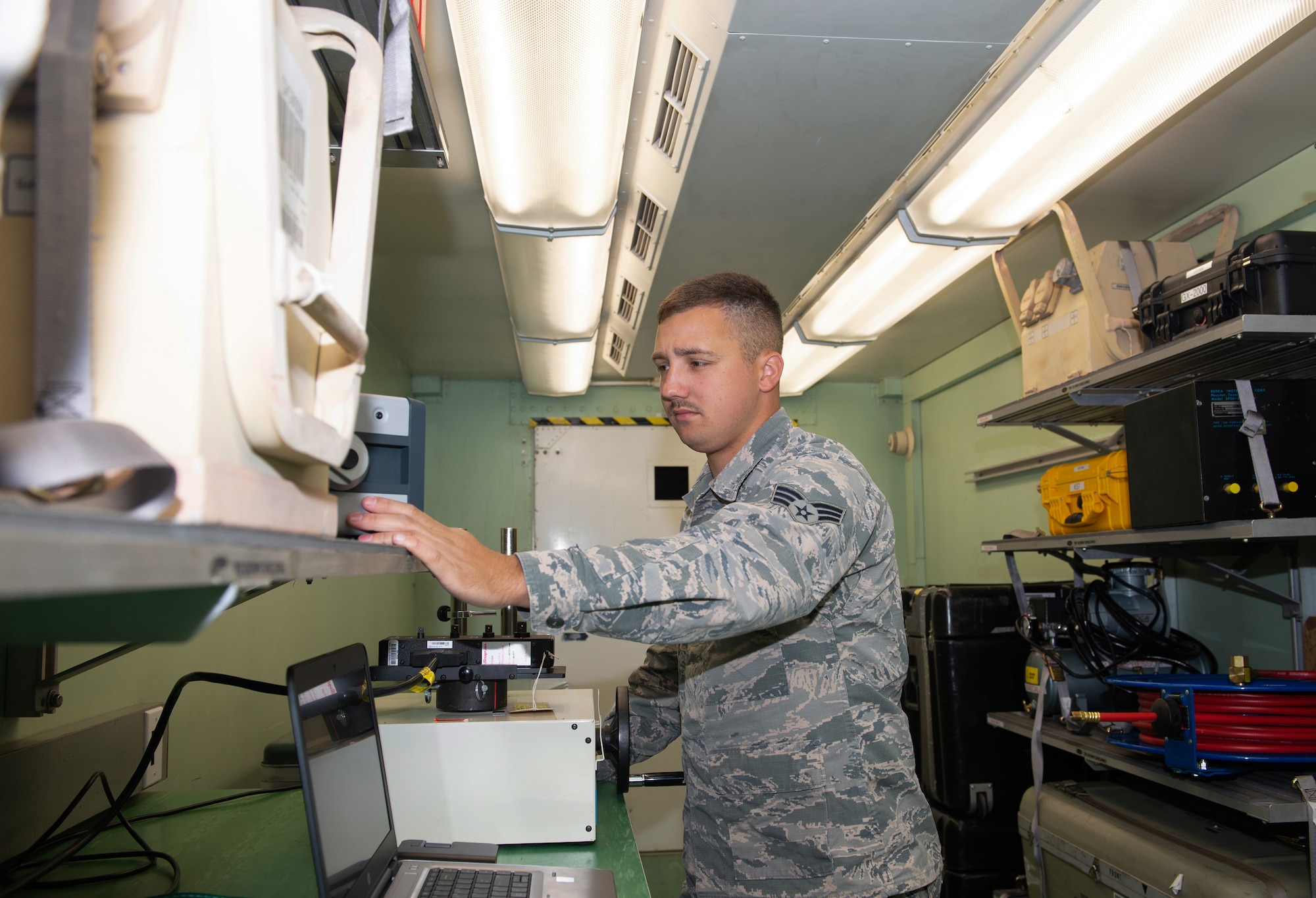 Senior Airman Jeremy Evans, a precision measurement equipment laboratory (PMEL) journeyman assigned to the 4th Component Maintenance Squadron at Seymour Johnson Air Force Base (AFB), North Carolina, checks a torque calibration station within a tactical shelter unit on May 6, 2019, at Offutt AFB, Nebraska. Evans is one of five PMEL experts sent here to set up the Rapid Assistance Support for Calibration to restore Offutt’s capability to calibrate equipment, which was lost in the flood earlier this year. (U.S. Air Force photo by L. Cunningham)