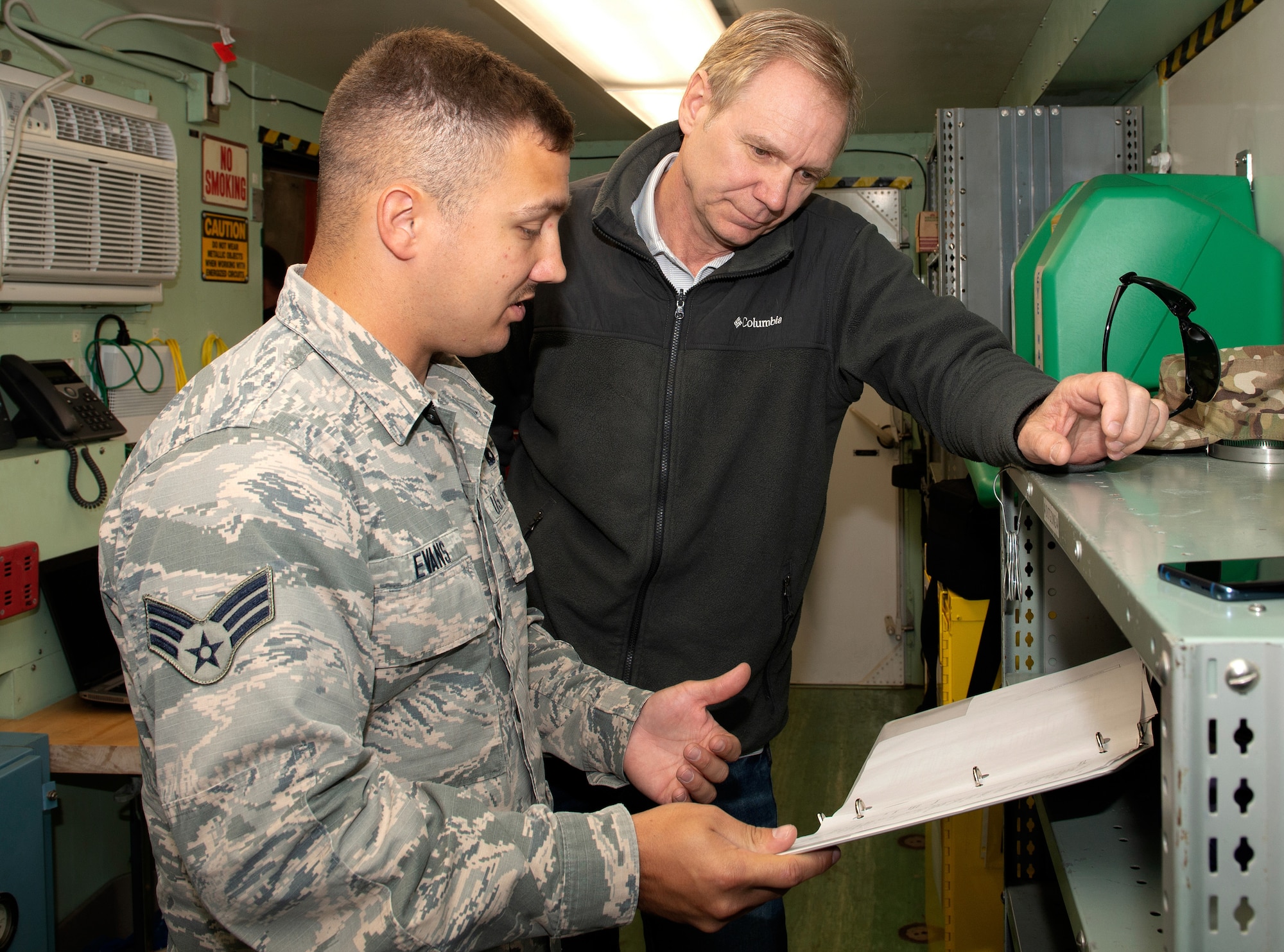 Senior Airman Jeremy Evans, a precision measurement equipment laboratory (PMEL) journeyman assigned to the 4th Component Maintenance Squadron at Seymour Johnson Air Force Base (AFB), North Carolina, explains the procedures outlined in the unit operating instructions for a Rapid Assistance Support for Calibration unit to Paul Hamel, 55th Maintenance Squadron PMEL site manager, May 6, 2019, at Offutt Air Force Base, Nebraska. The PMEL shop here is responsible for the repair and calibration of 6,000 pieces of Test Measurement Diagnostic Equipment that support the 55 Wing’s mission. (U.S. Air Force photo by L. Cunningham)