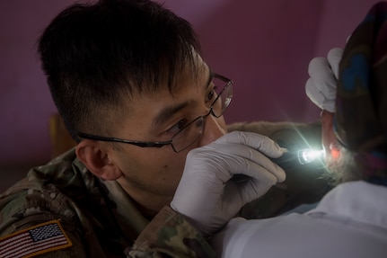U.S. Army Sgt. Frank Louie-Arishita, Joint Task Force – Bravo Medical Element practical nurse, looks inside a patient’s ear as part of a health screening during a Medical Readiness Training Exercise (MEDRETE), May 9, 2019, in El Paraiso, Honduras. Members of JTF-B partnered with the Honduran Military and Ministry of Health to provide health care services for more than 1,300 Honduran citizens; reaching a third of the citizens in the towns of Argelia, Santa Maria and Las Dificultades in the El Paraiso Department. The goal of the mission was to provide the medical staff training in their areas of expertise as well as strengthen partnerships with the Honduran allies. (U.S. Air Force photo by Staff Sgt. Eric Summers Jr.)