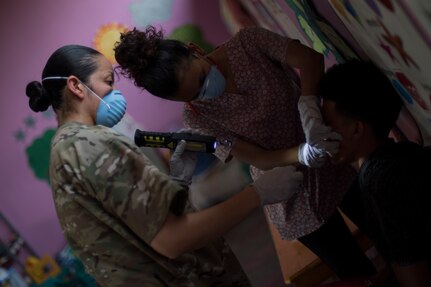 U.S. Army Sgt. Caroline Fuel, Joint Task Force – Bravo Medical Element dental sergeant, holds a light while a Honduran dentist examines a patient during a Medical Readiness Training Exercise (MEDRETE), May 9, 2019, in El Paraiso, Honduras. Members of JTF-B partnered with the Honduran Military and Ministry of Health to provide health care services for more than 1,300 Honduran citizens; reaching a third of the citizens in the towns of Argelia, Santa Maria and Las Dificultades in the El Paraiso Department. The goal of the mission was to provide the medical staff training in their areas of expertise as well as strengthen partnerships with the Honduran allies. (U.S. Air Force photo by Staff Sgt. Eric Summers Jr.)