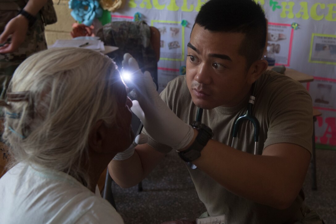 U.S. Army Spc. Alec Pagtakhan, Joint Task Force – Bravo Medical Element EMT medic, looks for signs of eye ailments as part of a medical screening during a Medical Readiness Training Exercise (MEDRETE), May 10, 2019, in El Paraiso, Honduras. Members of JTF-B partnered with the Honduran Military and Ministry of Health to provide health care services for more than 1,300 Honduran citizens; reaching a third of the citizens in the towns of Argelia, Santa Maria and Las Dificultades in the El Paraiso Department. The goal of the mission was to provide the medical staff training in their areas of expertise as well as strengthen partnerships with the Honduran allies. (U.S. Air Force photo by Staff Sgt. Eric Summers Jr.)