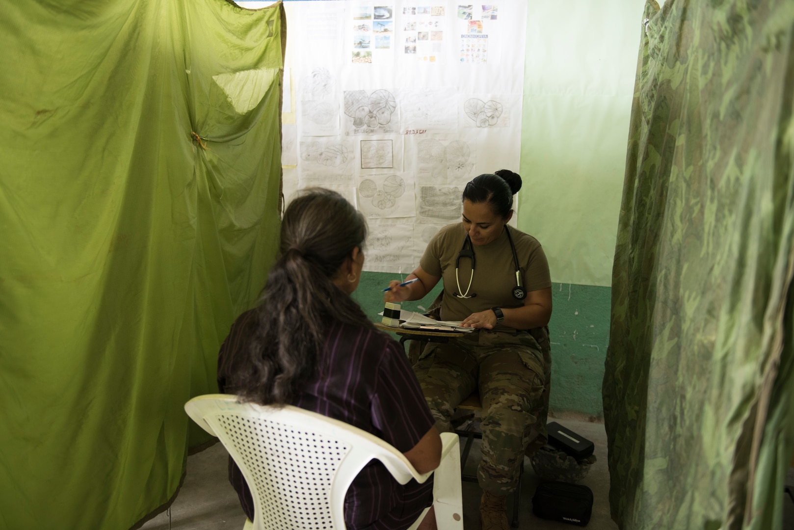 U.S. Army Capt. Sayda Fairfield, Joint Task Force – Bravo Medical Element physician assistant, address the concerns of a patient during a Medical Civil Action Program (MEDCAP), May 11, 2019, in El Paraiso, Honduras. Members of JTF-B partnered with the Honduran Military and Ministry of Health to provide health care services for more than 1,300 Honduran citizens; reaching a third of the citizens in the towns of Argelia, Santa Maria and Las Dificultades in the El Paraiso Department. The goal of the mission was to provide the medical staff training in their areas of expertise as well as strengthen partnerships with the Honduran allies. (U.S. Air Force photo by Staff Sgt. Eric Summers Jr.)