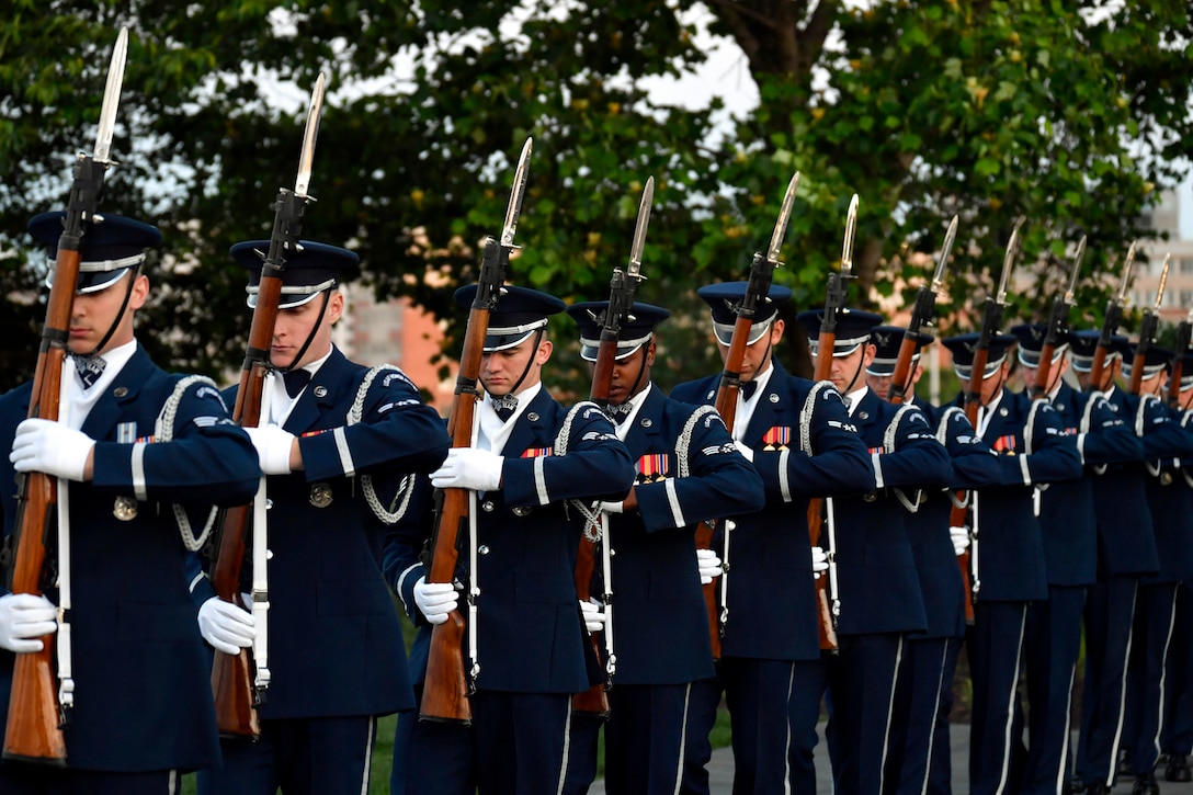 Service members participate in a honor guard routine.