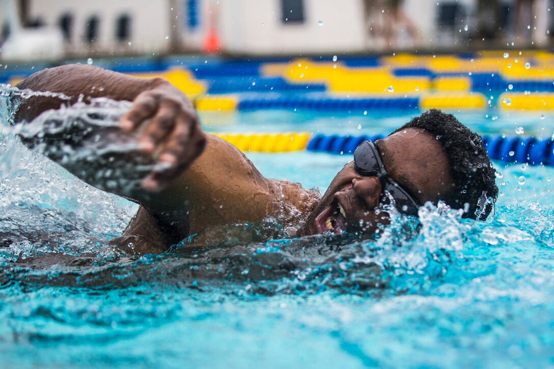 A Marine swims in a pool.