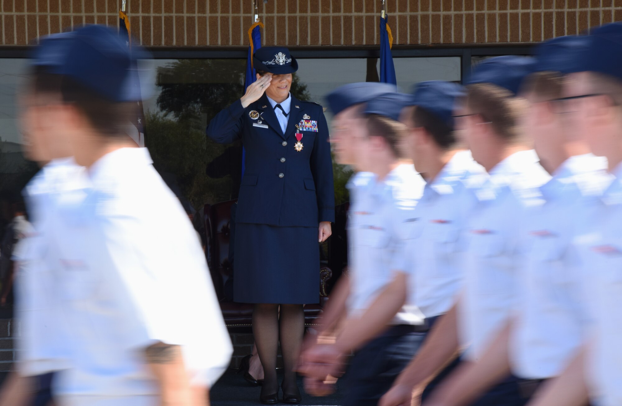 U.S. Air Force Col. Debra Lovette, outgoing 81st Training Wing commander, salutes Airmen as they march by during the change of command ceremony on the Levitow Training Support Facility drill pad at Keesler Air Force Base, Mississippi, May 16, 2019. The ceremony is a symbol of command being exchanged from one commander to the next by the handing-off of a ceremonial guidon. Lovette is now assigned to the U.S. Space Command. (U.S. Air Force photo by Kemberly Groue)