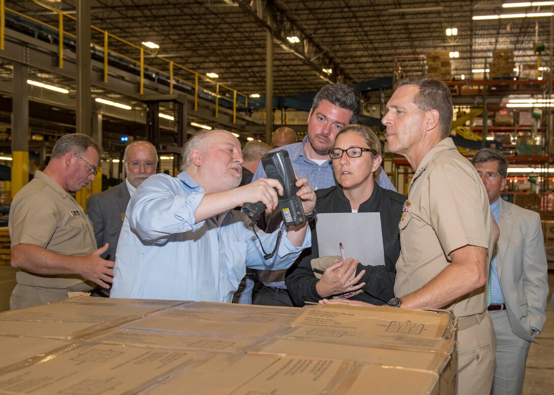 A group of people look at a device.