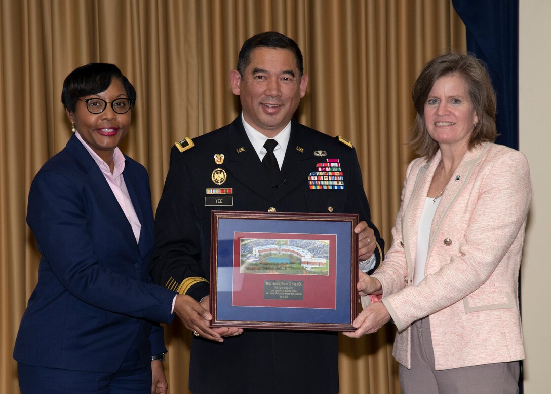 Two women present plaque to guest speaker Army Maj. Gen. Garrett Yee