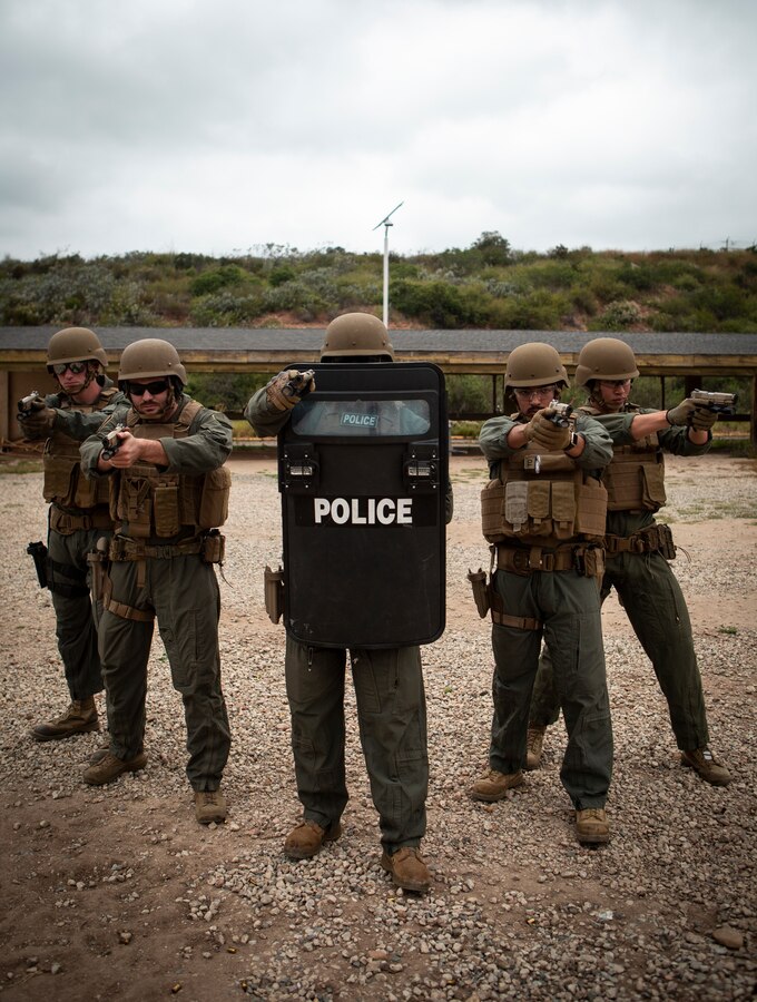 Marines with the Marine Corps Air Station Miramar Special Reactions Team (SRT) pose for a photograph in front of a tripod during training at MCAS Miramar, Calif., May 15. The Marines conducted this training to hone their skills in close quarters combat and further familiarize themselves with the M1911 Service Pistol. (U.S. Marine Corps photo by Sgt. Becky Cleveland)