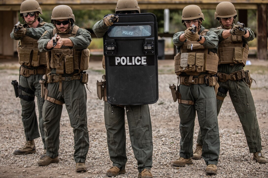 Marines with the Marine Corps Air Station Miramar Special Reactions Team (SRT) pose for a photograph in front of a tripod during training at MCAS Miramar, Calif., May 15. The Marines conducted this training to hone their skills in close quarters combat and further familiarize themselves with the M1911 Service Pistol. (U.S. Marine Corps photo by Sgt. Jake McClung)