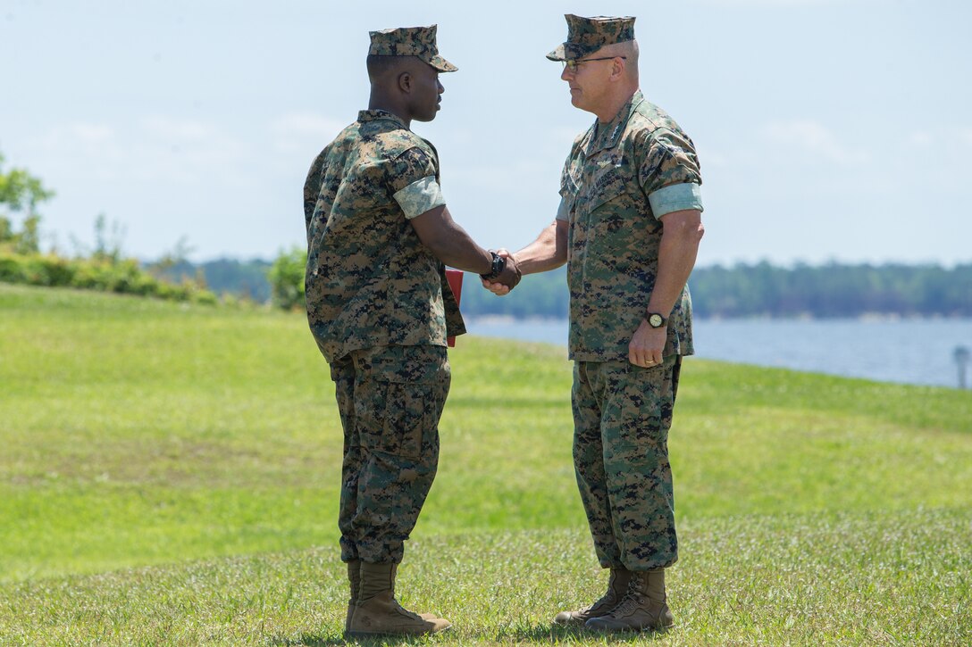 U.S. Marine Corps Lt. Gen. Robert F. Hedelund, right, commanding general of II Marine Expeditionary Force, shakes hands with Cpl. Lance F. Sumo, 2nd Supply Battalion, Combat Logistics Regiment 25, 2nd Marine Logistics Group, during an award ceremony at Camp Lejeune, North Carolina, May 14, 2019. During the ceremony, annual awards were presented to Marines and Sailors who displayed exceptional work ethic and leadership qualities. (U.S. Marine Corps photo by Cpl. Tyler Stewart)