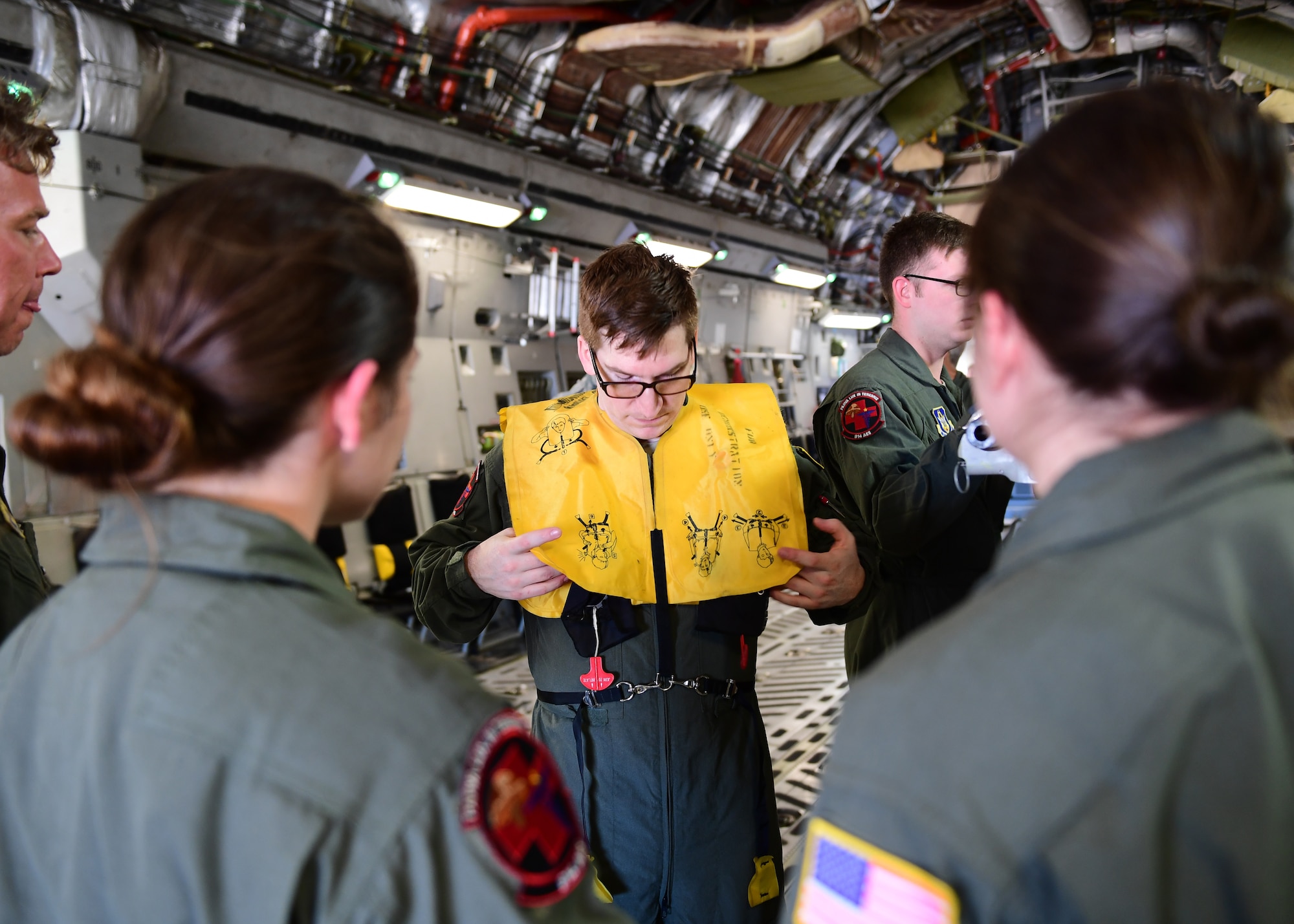 Staff Sgt. John Klobushnik, 914th Aeromedical Evacuation Squadron medical technician, teaches other medical technicians from the 914th AES about proper life vest procedures at Barbers Point Airfield, Hawaii April 24, 2019. This was the last of the safety procedures before the flight took off and dissimilar aircraft training began. (U.S. Air Force photo by Senior Airman Grace Thomson)