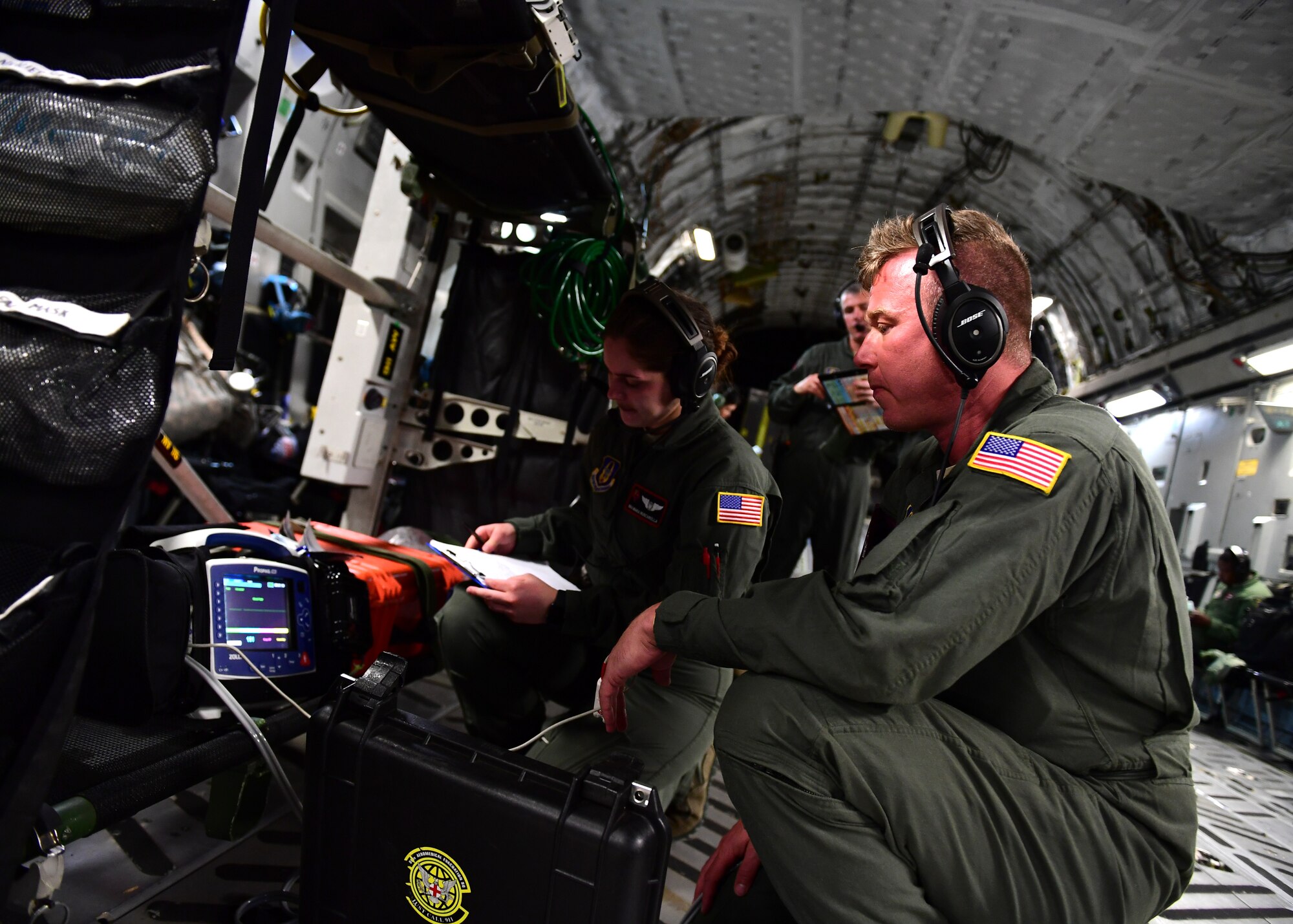 Senior Airman Maria Muscarella and Staff Sgt. Raymond Johnson, Airmen with the 914th Aeromedical Evacuation Squadron, check medical equipment while flying above Honolulu, Hawaii April 24, 2019. During the training mission the equipment was checked several times to ensure it was all in working order and to ensure everyone checked the equipment. (U.S. Air Force photo by Senior Airman Grace Thomson)