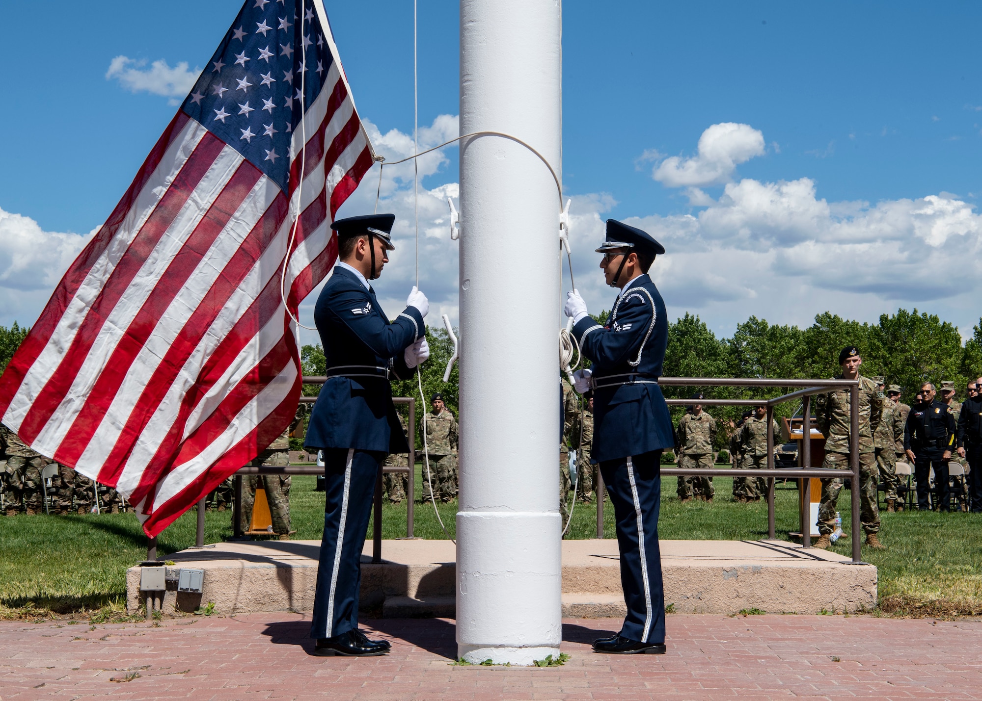 Kirtland Air Force Base Honor Guardsmen prepare to hoist the flag after lowering it from half-staff during the Police Week Memorial Retreat Ceremony at Kirtland Air Force Base, N.M., May 15. When lowering the flag from half-staff, it must first be hoisted to the peak before being lowered. (U.S. Air Force photo by Staff Sgt. J.D. Strong II)