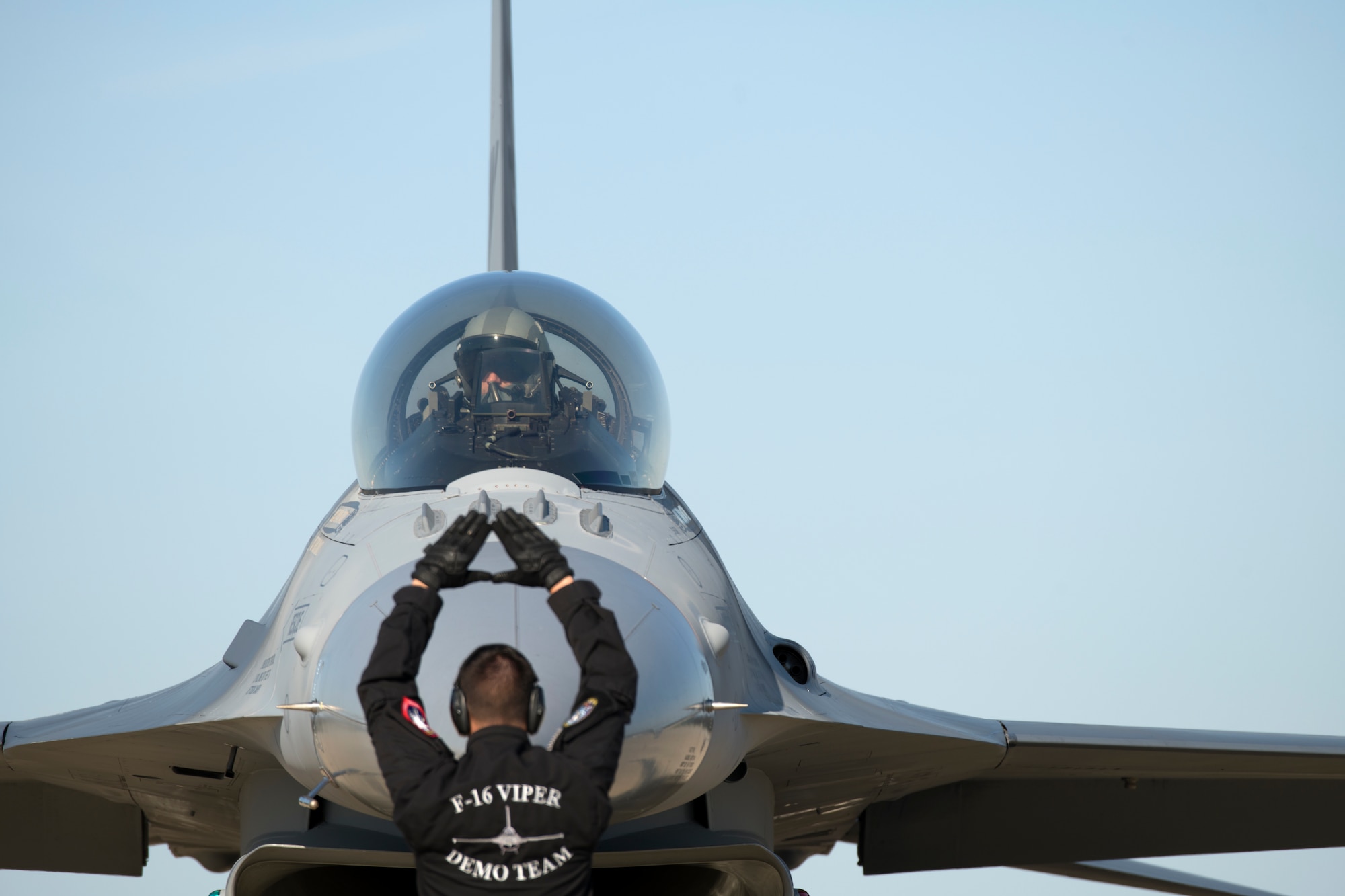 U.S. Air Force Staff Sgt. Austin Dixon, F-16 Viper Demonstration Team (VDT) dedicated crew chief, signals Maj. Garret “Toro” Schmitz, F-16 VDT commander and pilot, to stop his aircraft on the flight line at Joint Base Langley-Eustis, Va., May 16, 2019.