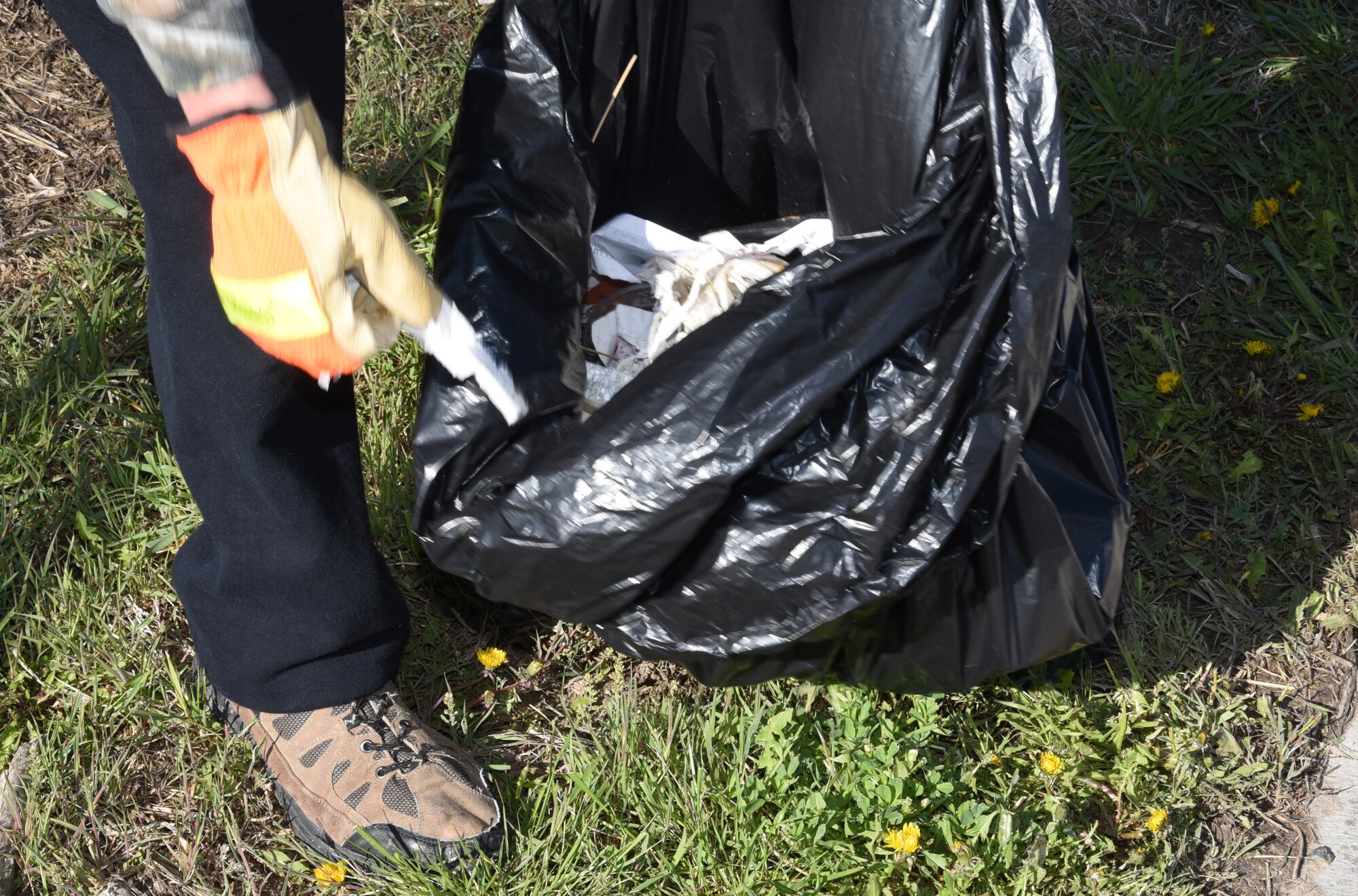 SSgt. Joshua Midla from the 90th Logistics Readiness Squadron cleans trash off the Cheyenne Greenway near the Crow Creek in Cheyenne, Wyo., May 11. More than fifty volunteers came out as part of the Crow Creek Revival project aimed at bringing the creek closer to its original state