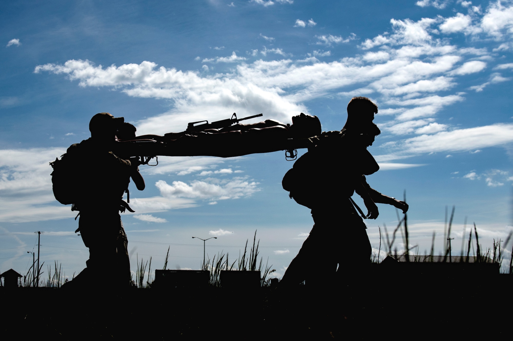 Airmen from the 92nd Security Forces Squadron compete in the Defender Challenge by executing a litter carry during National Police Week at Fairchild Air Force Base, Washington, May 16, 2019. The 92nd SFS hosts a week-long celebration to honor the lives lost through a memorial Fallen Defender Ruck, a law enforcement exposition for the kids, a retreat ceremony and a battle of the badge competition between security forces and the fire department. (U.S. Air Force photo by Airman 1st Class Whitney Laine)